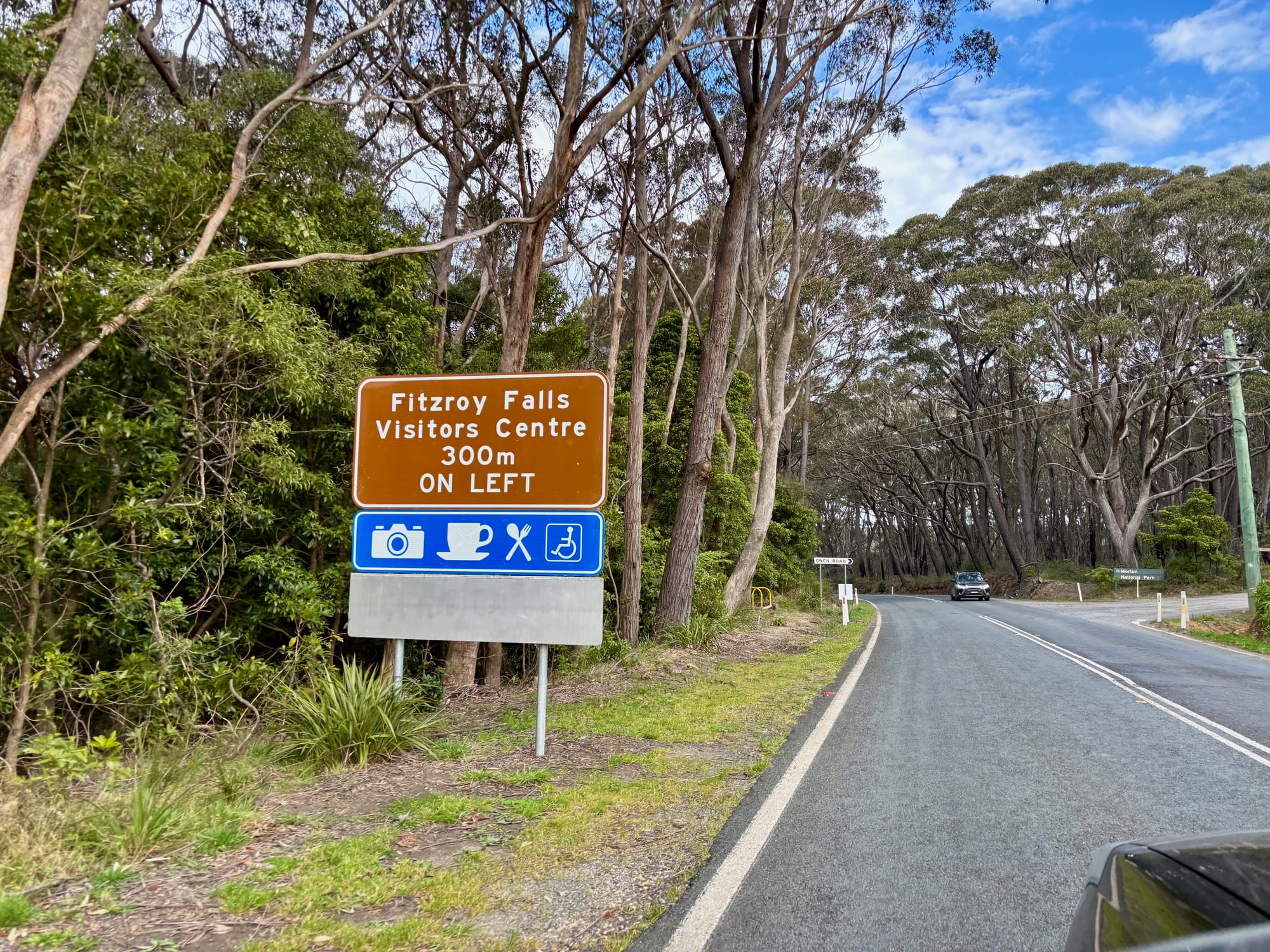 The brown road sign for the Fitzroy Falls Visitors Centre, 300 m on the left