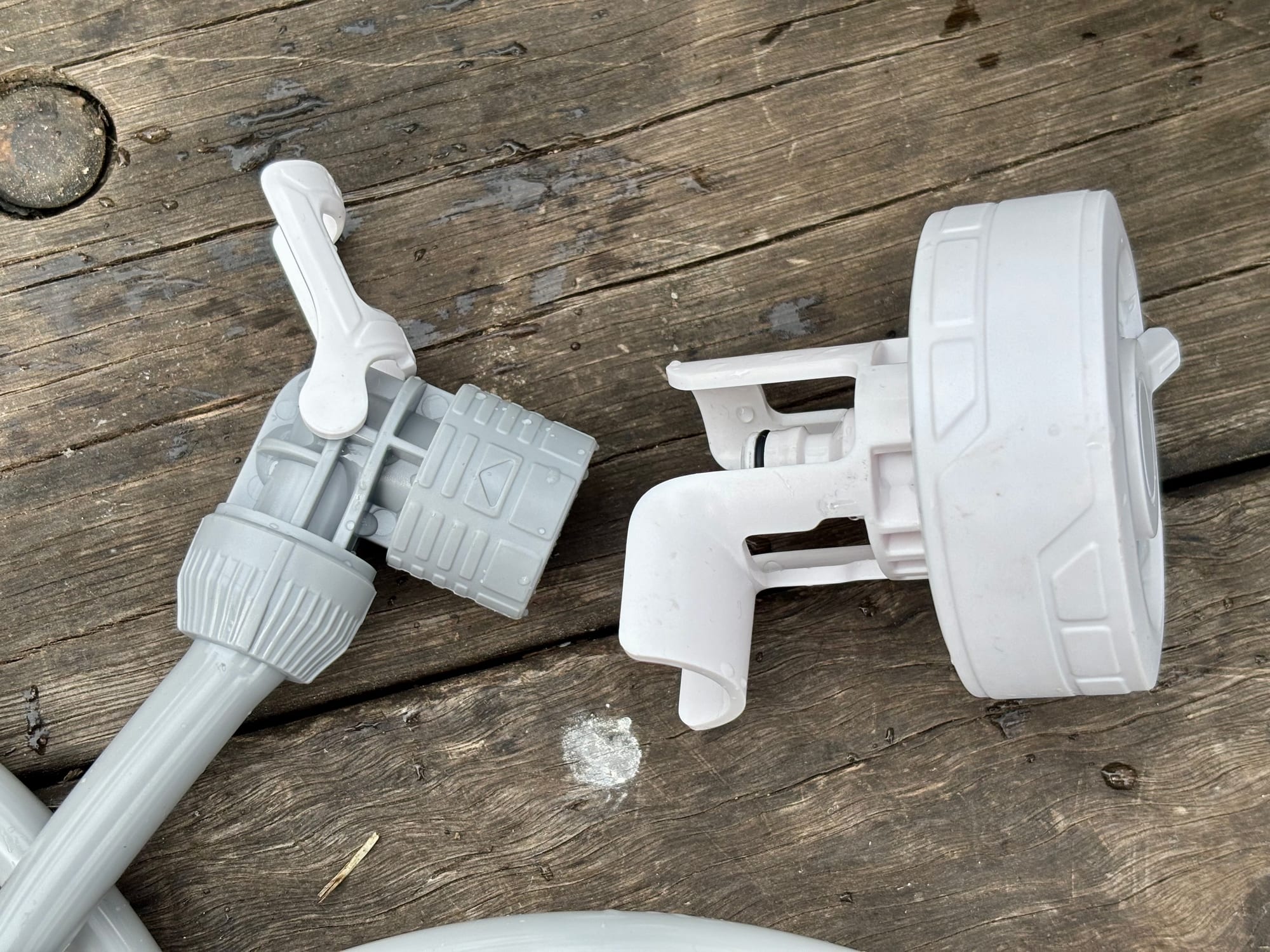The hose end with its fold-out hook next to the shower head of the FlexTail Max Shower