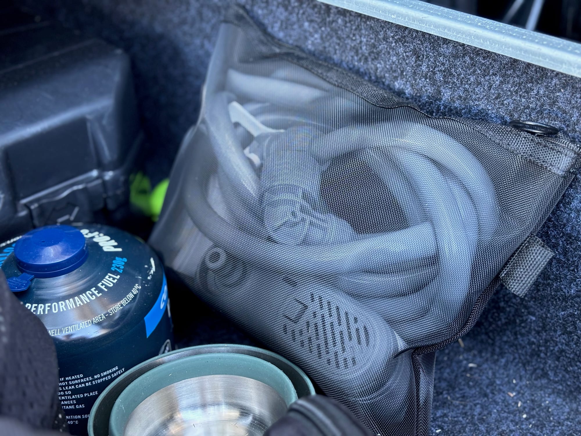 The FlexTail Max Shower pump, hose and shower head packed in a mesh bag in a drawer of the 4WD