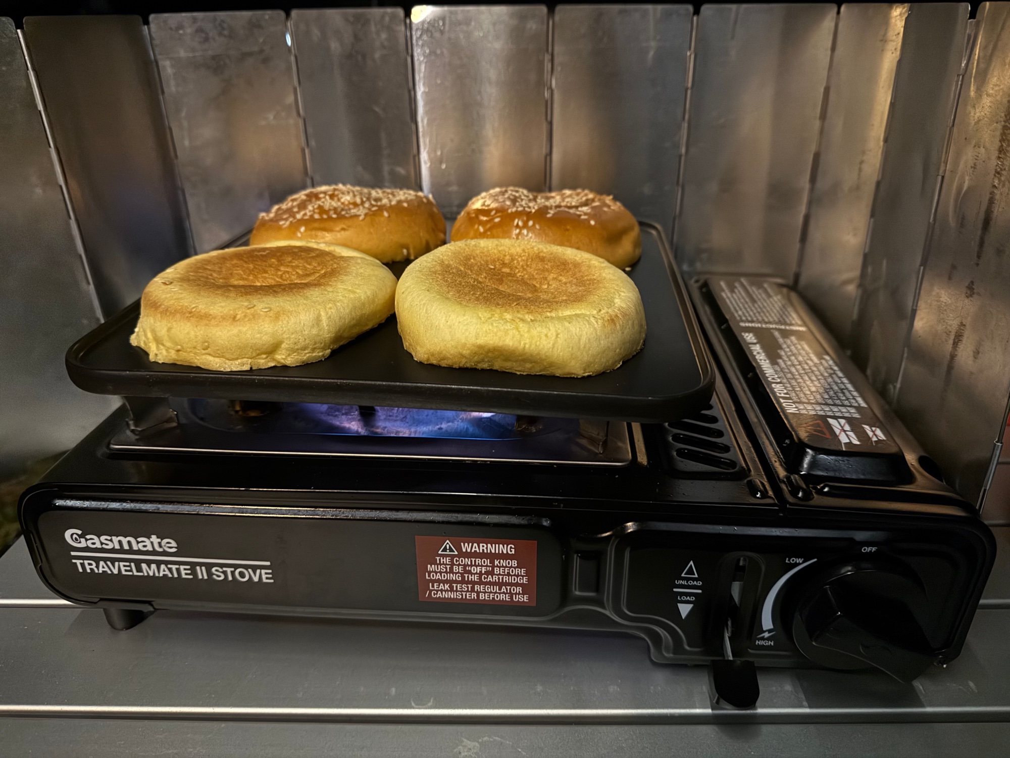 Hamburger buns toasting on the Gasmate Travelmate II hotplate at night