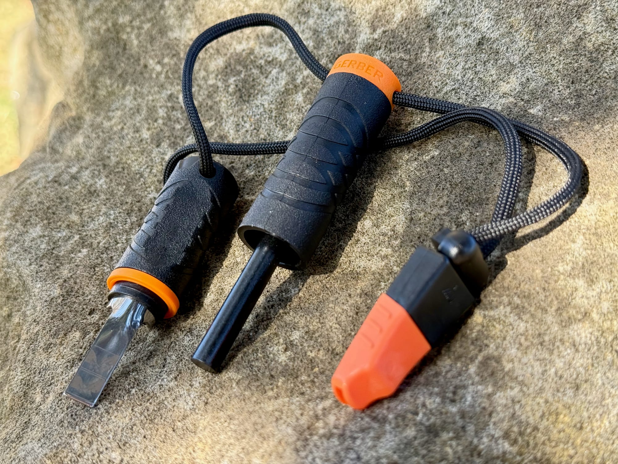 The Gerber Fire Starter laid out: the striker, the ferro rod and the orange whistle on their lanyard