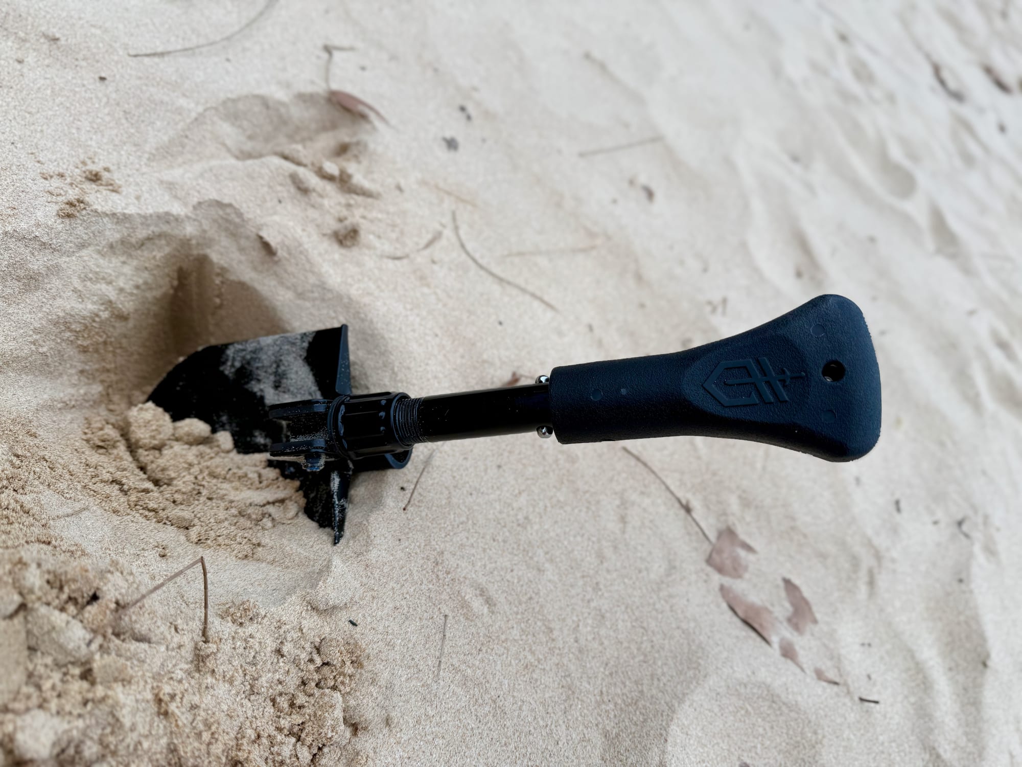 The Gerber Gorge folding shovel digging a hole in beach sand
