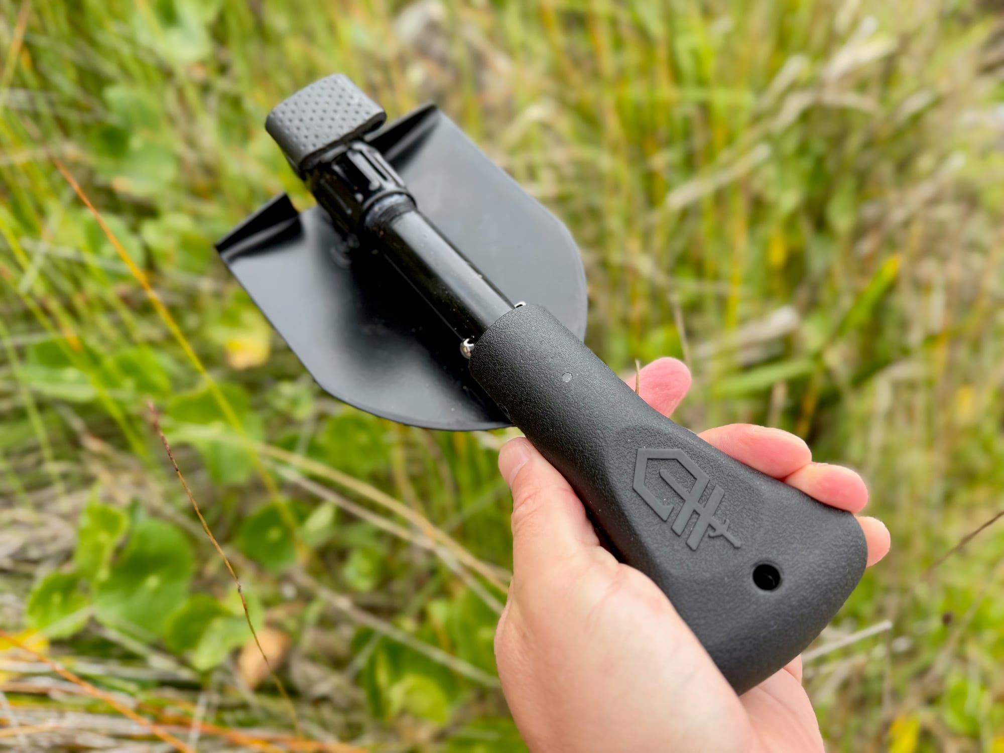 A hand holding the folded Gerber Gorge shovel by its wide handle