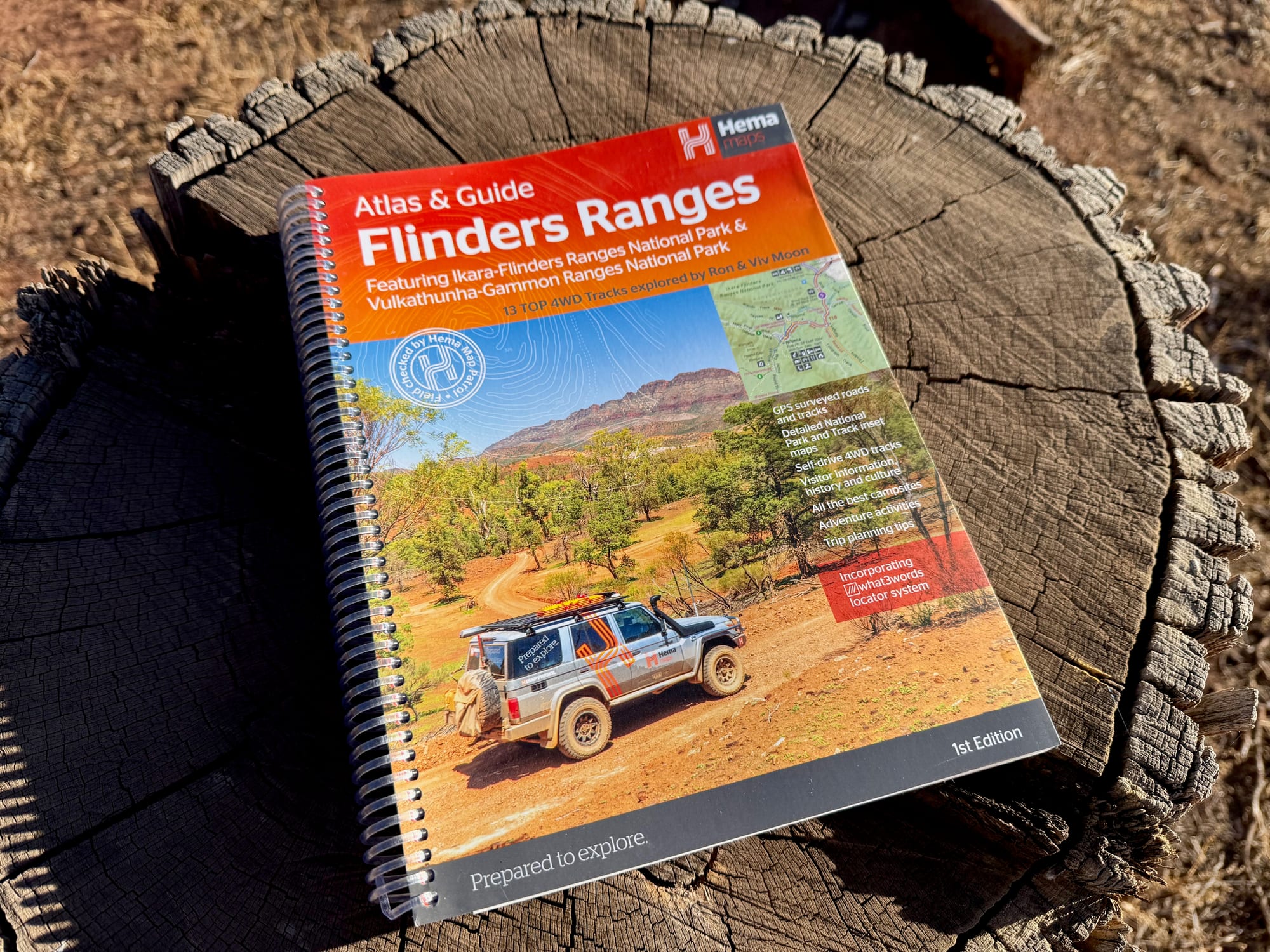 The cover of the Hema Atlas & Guide Flinders Ranges, 1st Edition, on a tree stump