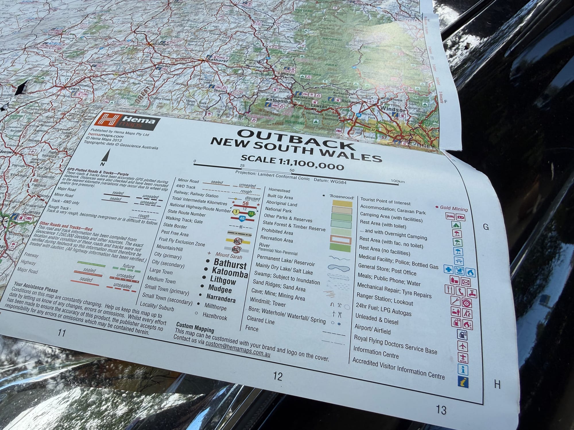 The legend of the Hema Outback New South Wales map, showing the 1:1,100,000 scale and the road and camping symbols