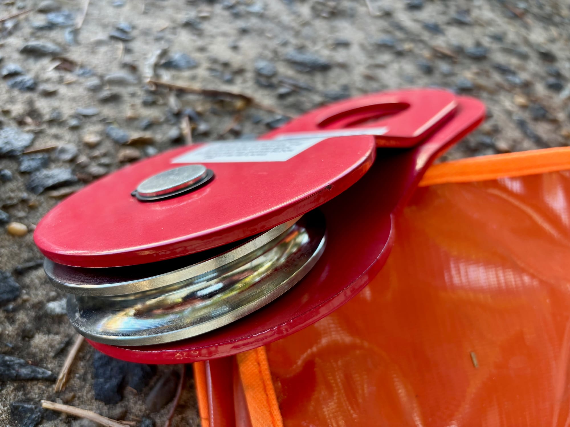 The red Hercules snatch block with its side plate swung open, showing the steel pulley