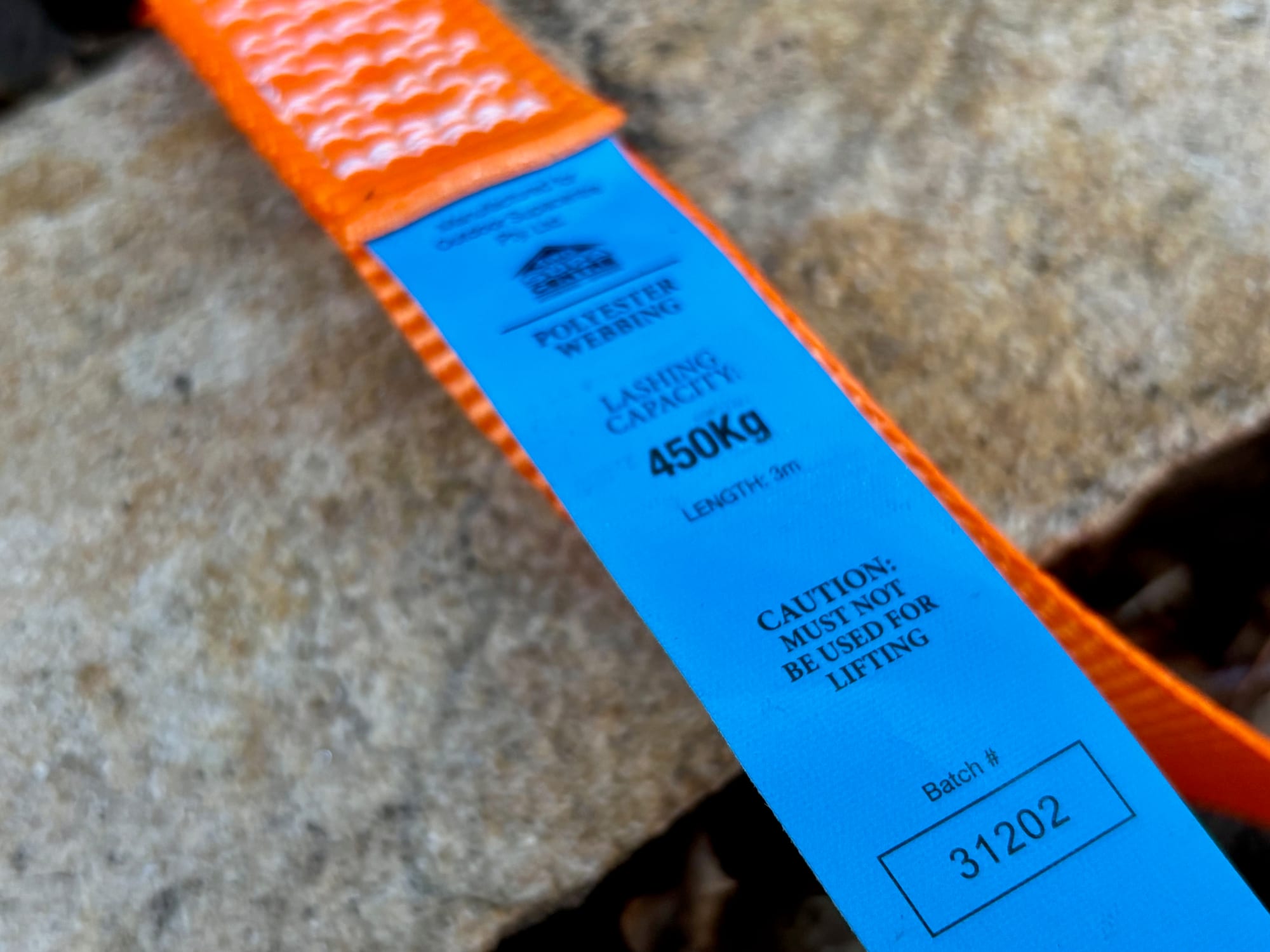 The blue tag on the orange webbing: polyester webbing, lashing capacity 450 kg, must not be used for lifting