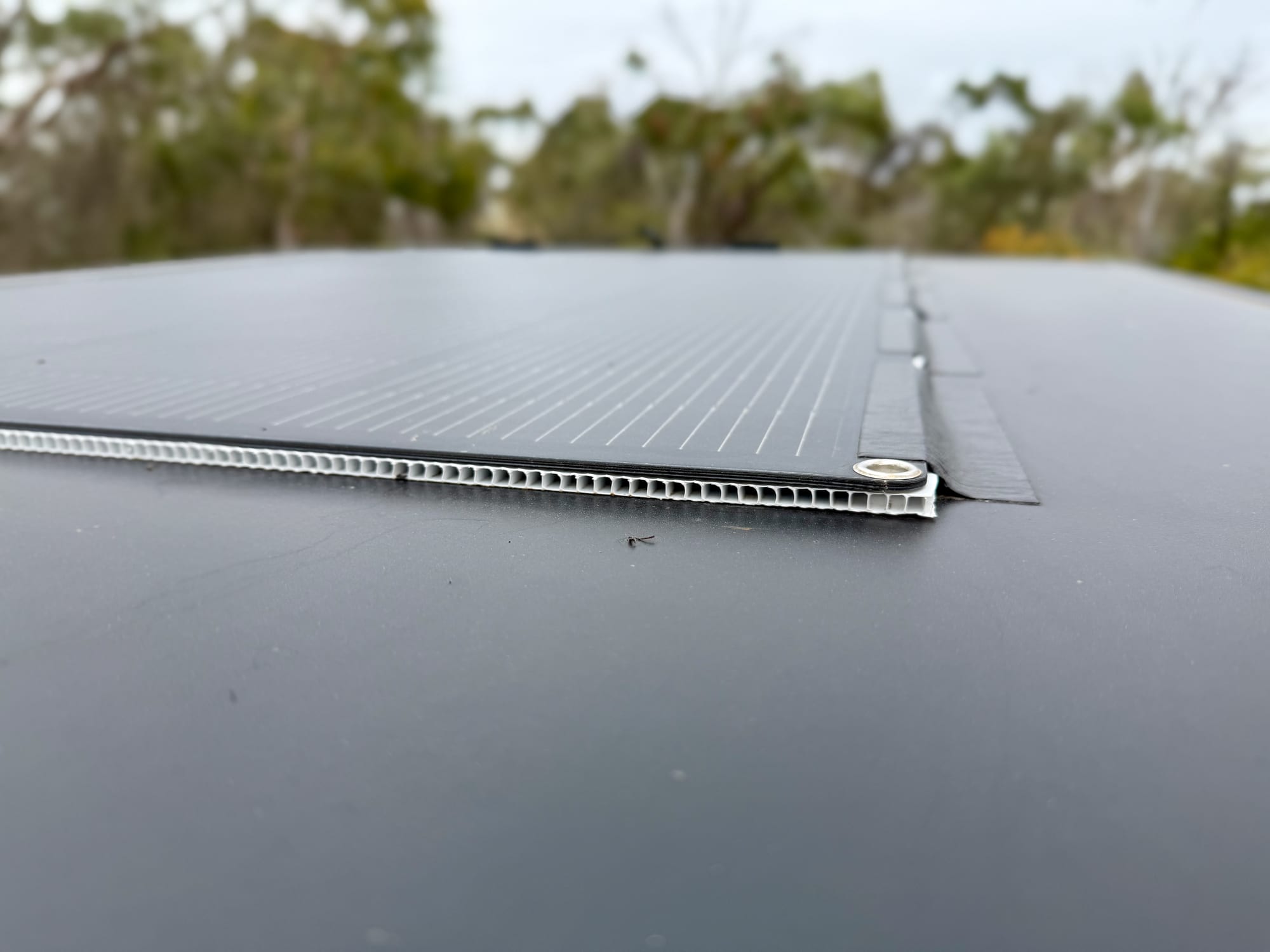 The finished edge of the flexible solar panel on the rooftop tent