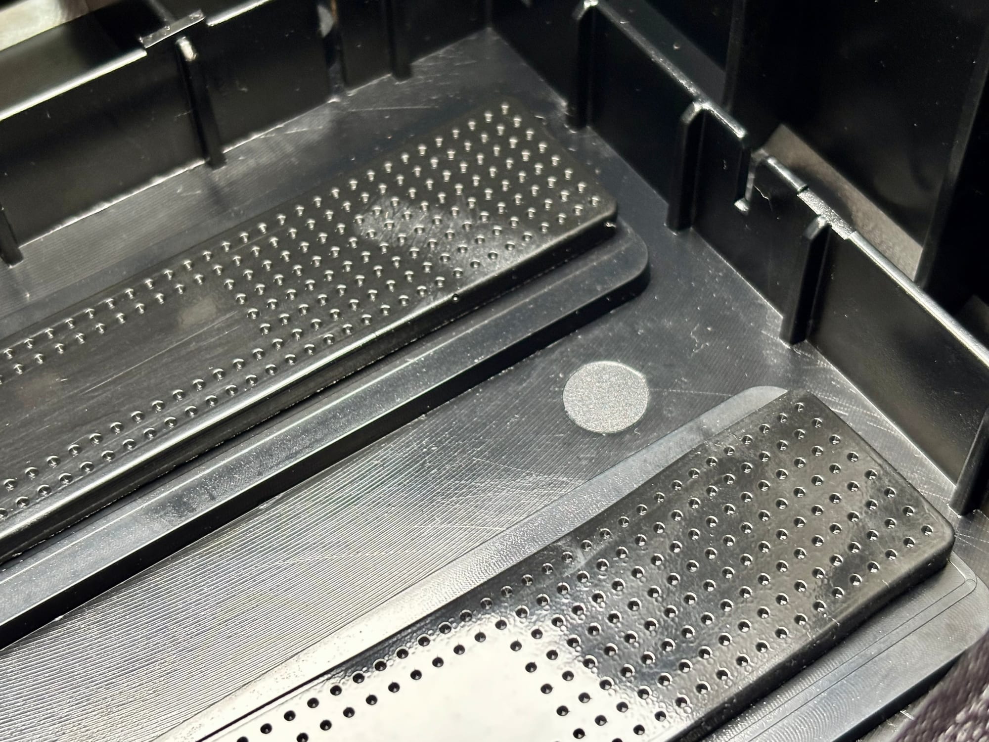 The adhesive foam pads stuck to the bottom of the BatBlock, before the battery goes in
