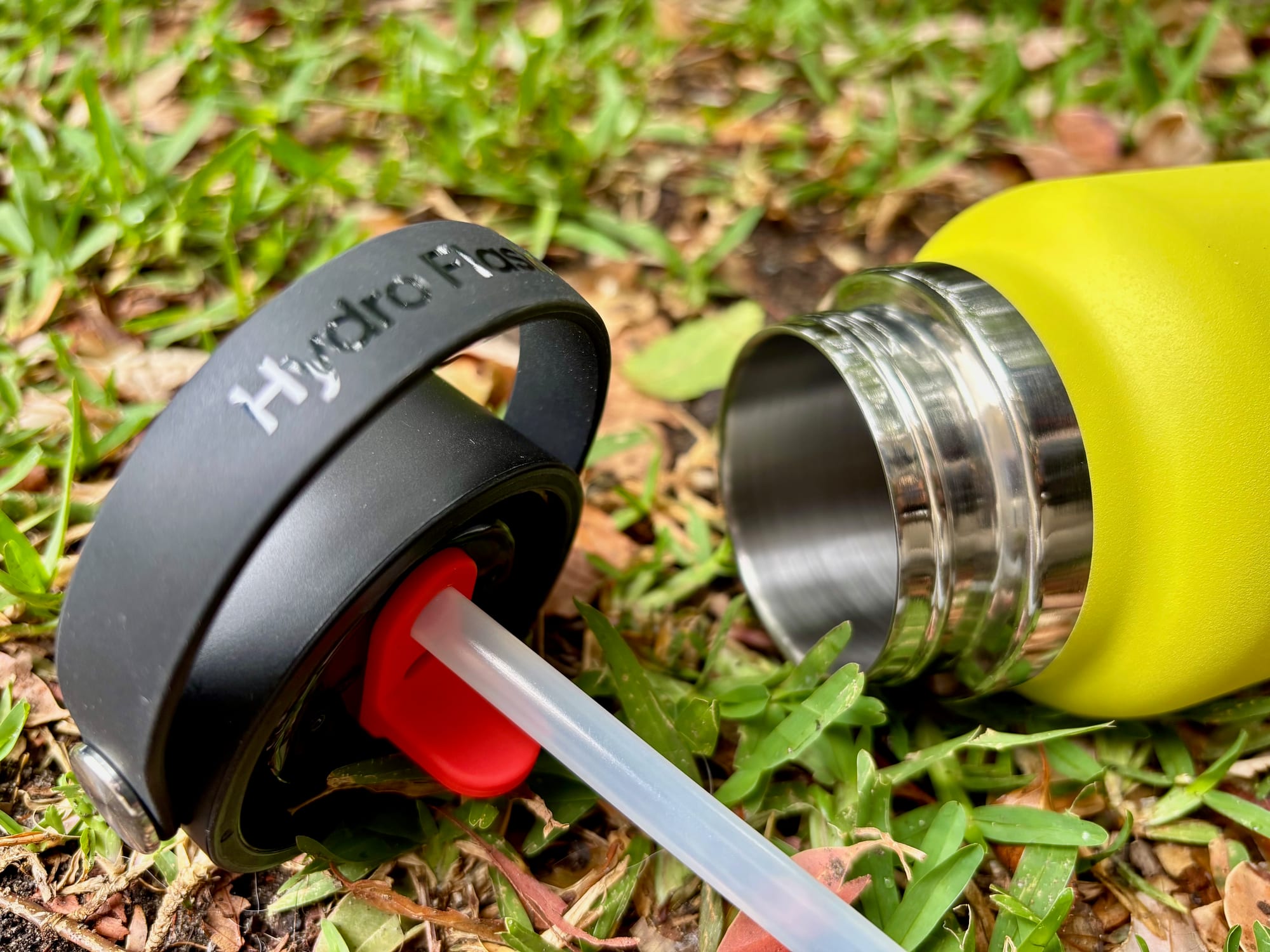 The cap unscrewed from the Hydro Flask, with its straw, next to the open wide mouth of the bottle