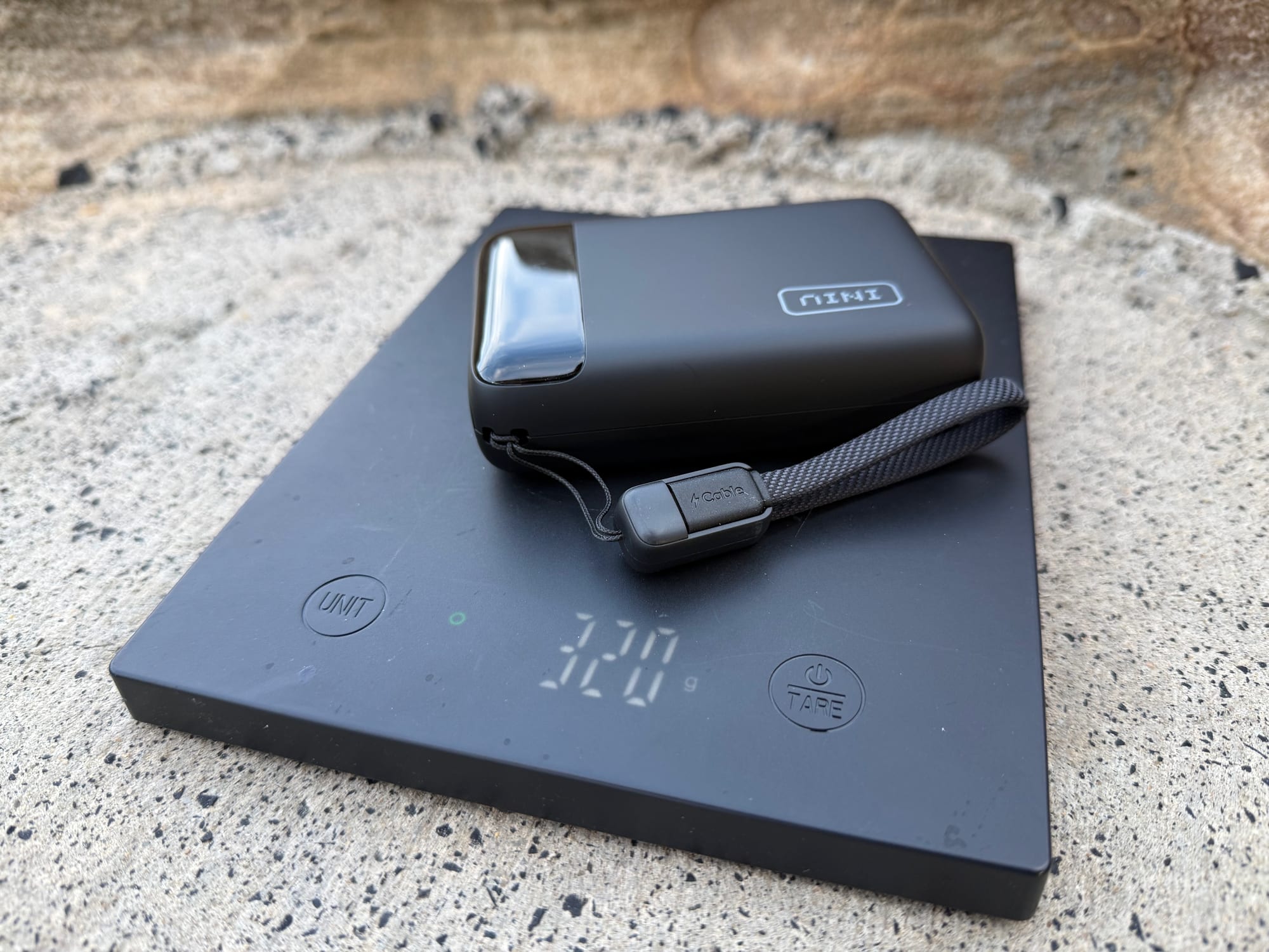 The INIU 20,000mAh power bank on a scale showing 320 g