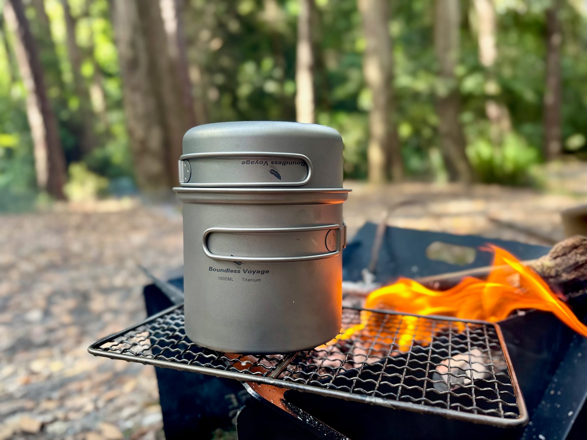 The titanium pot with the pan as its lid, nested together on a grill by the fire