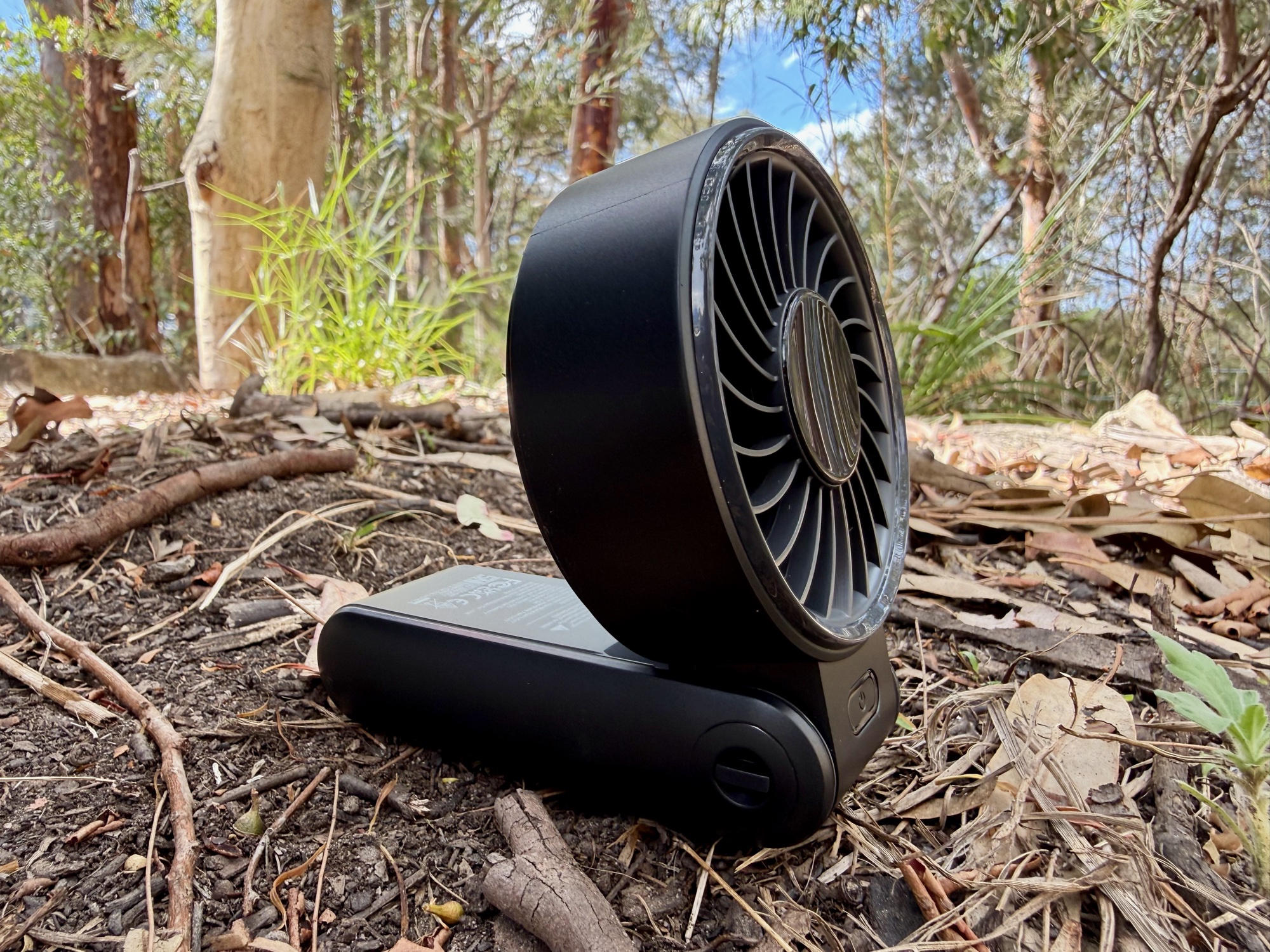 The JisuLife Life7 folded into its desk stand on the ground in the bush