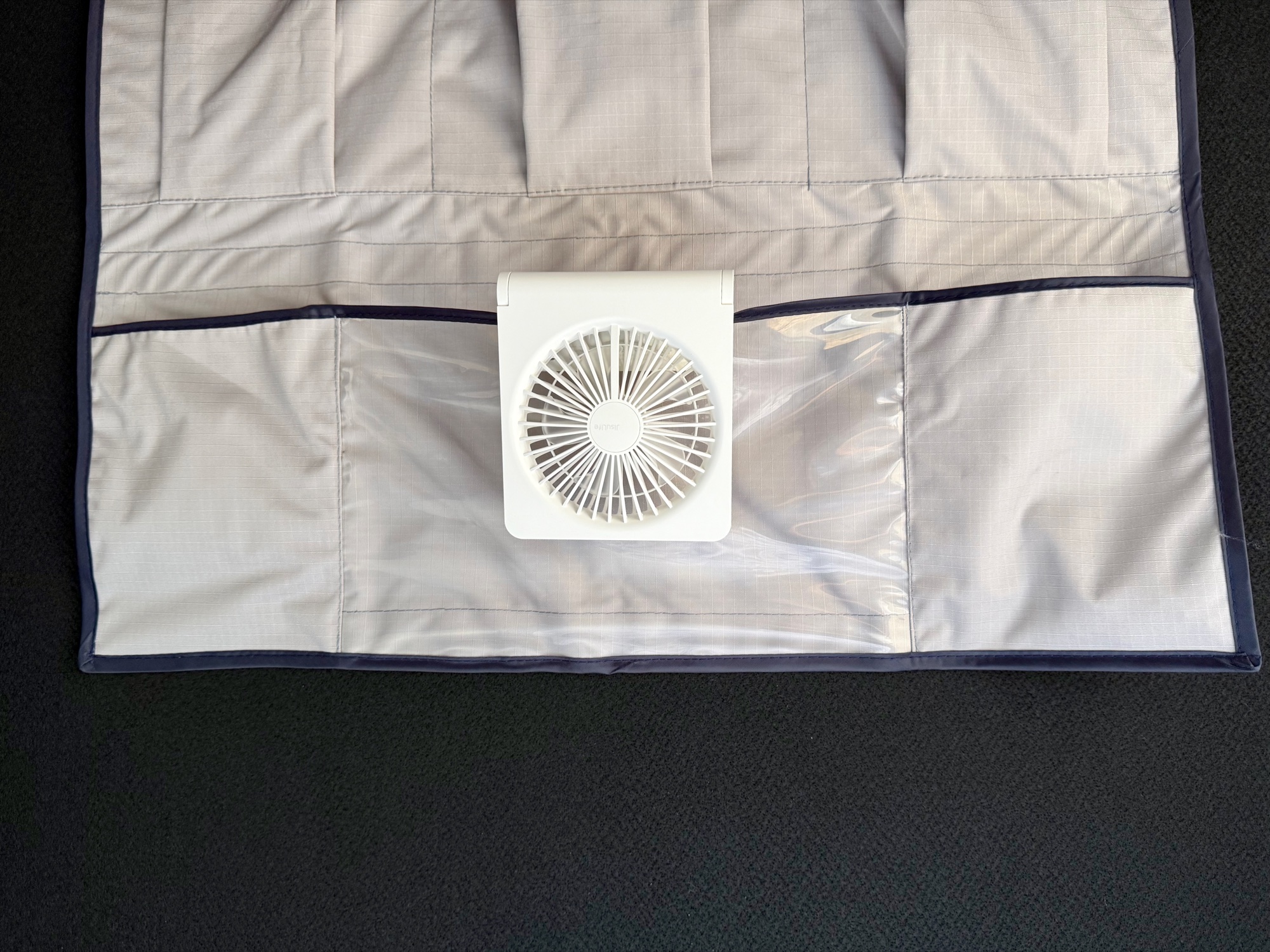 The white JisuLife Table Fan Life3 in the ceiling pocket of a rooftop tent