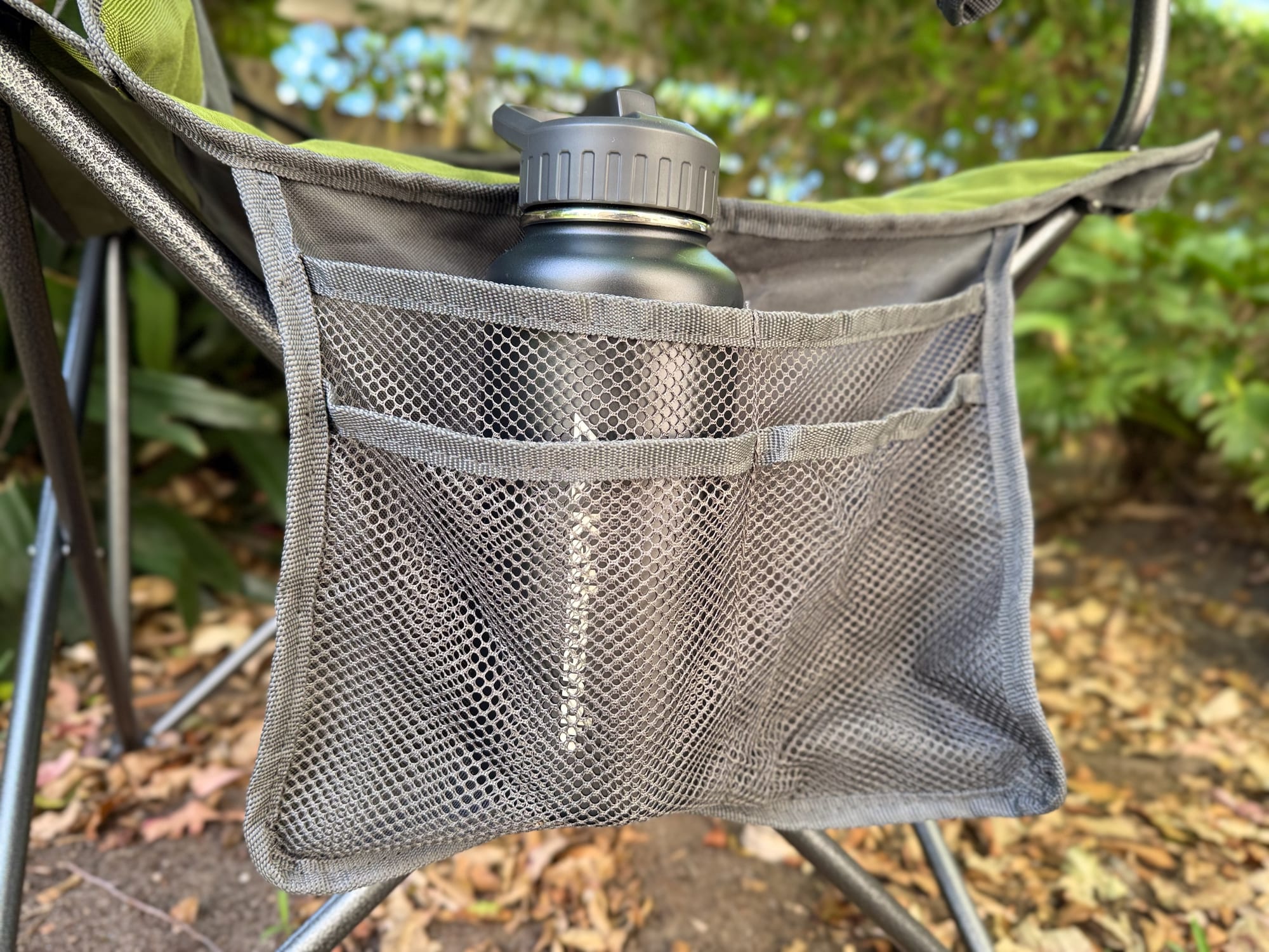 The Kathmandu bottle standing in the mesh side pocket of a camp chair