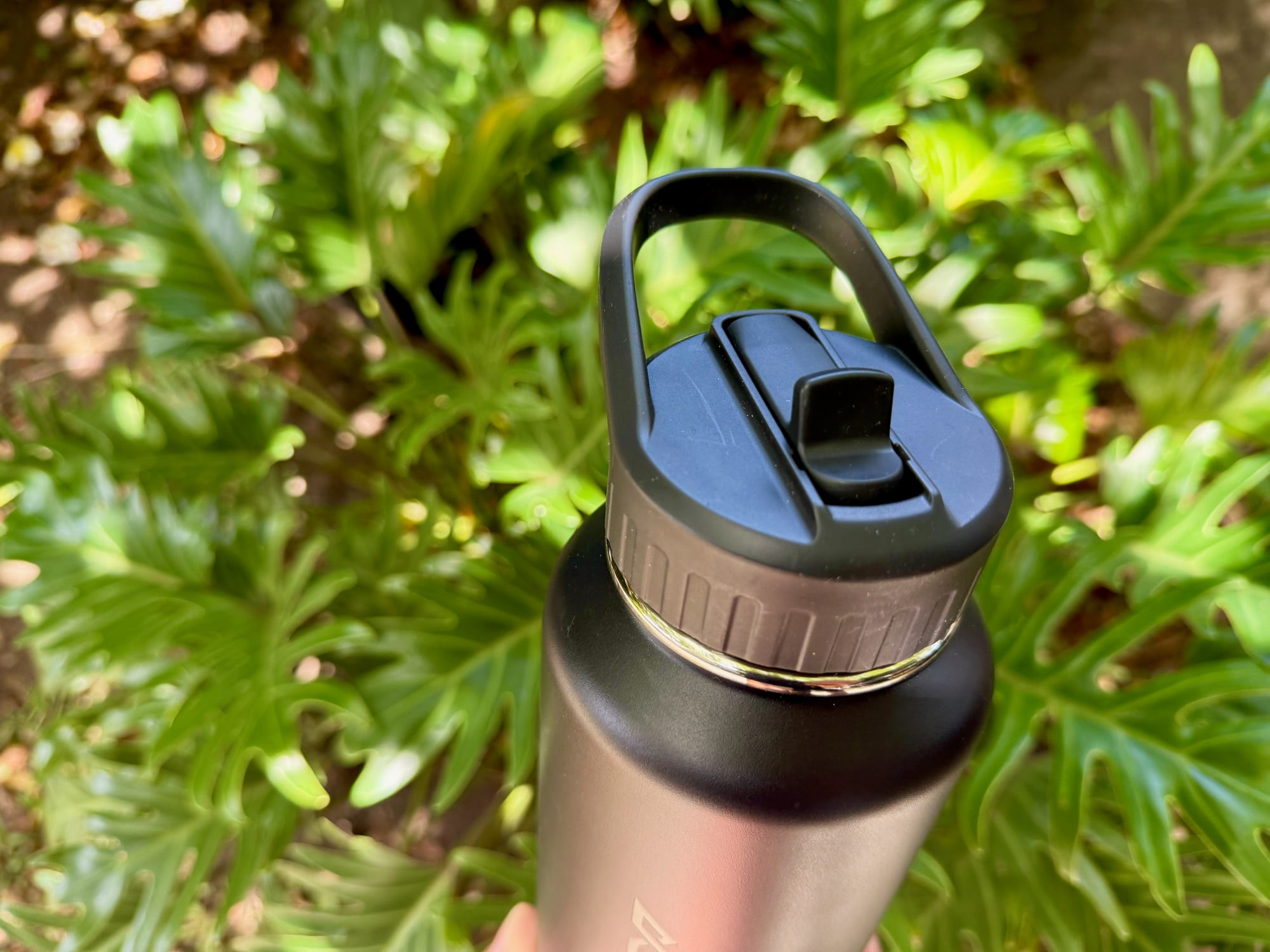 The straw lid of the Kathmandu bottle closed, with the spout folded down