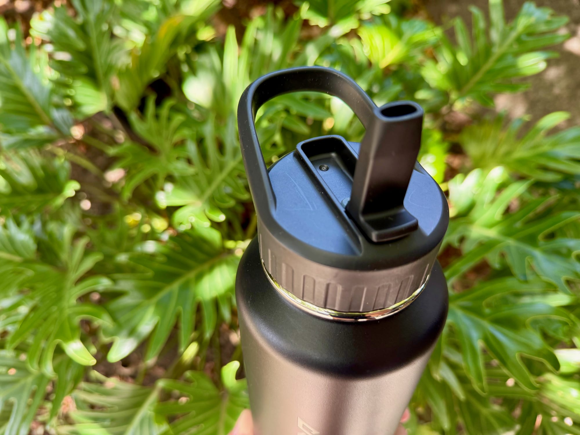 The Kathmandu Straw Lid Insulated Bottle with its straw flipped up