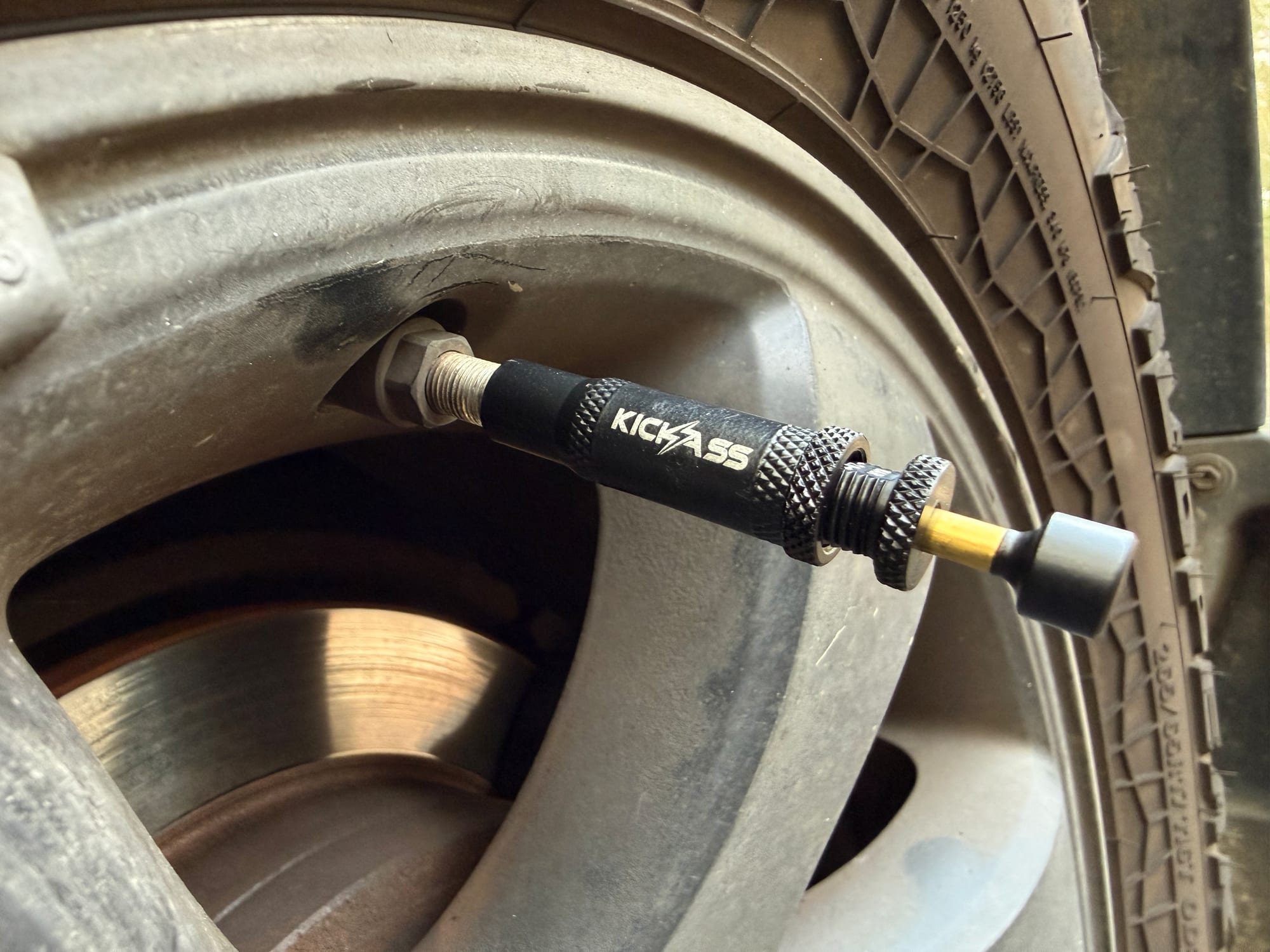 A KickAss deflator screwed onto the tyre valve of a Prado