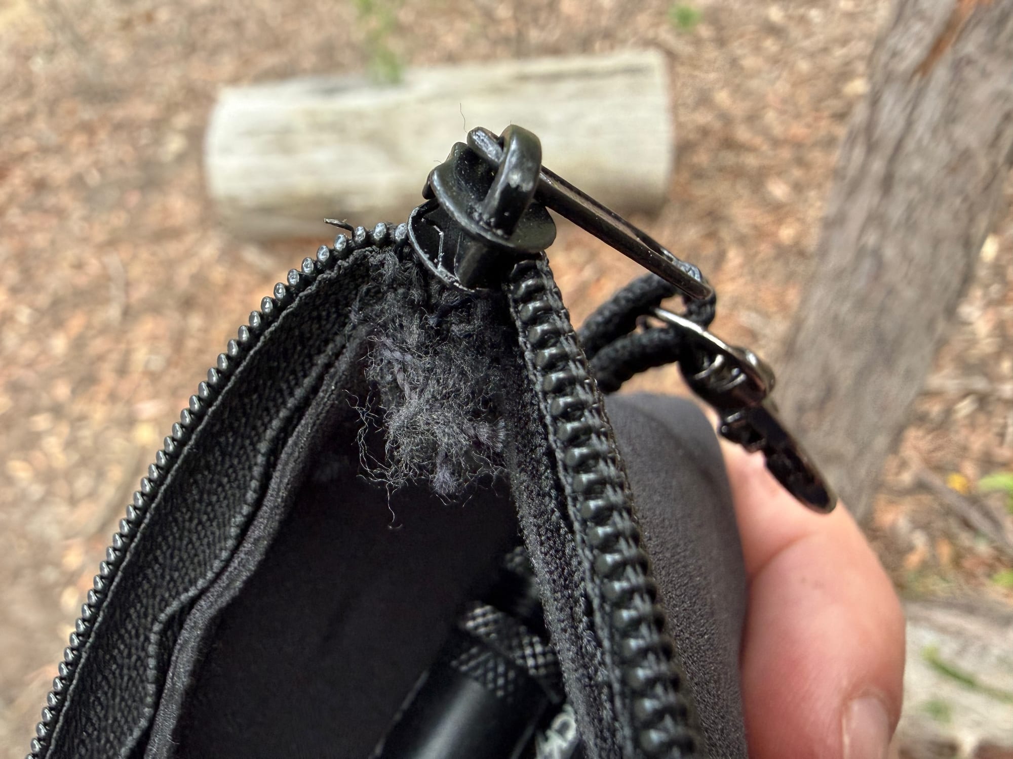 The end of the KickAss pouch zipper, where it has come loose from the pouch