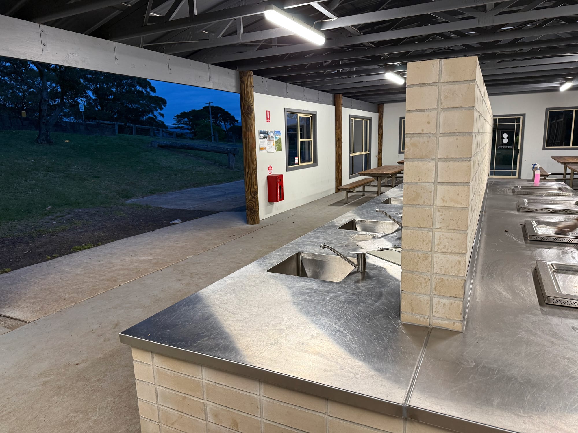 The stainless steel benches and sinks inside the camp kitchen at Killalea Campground