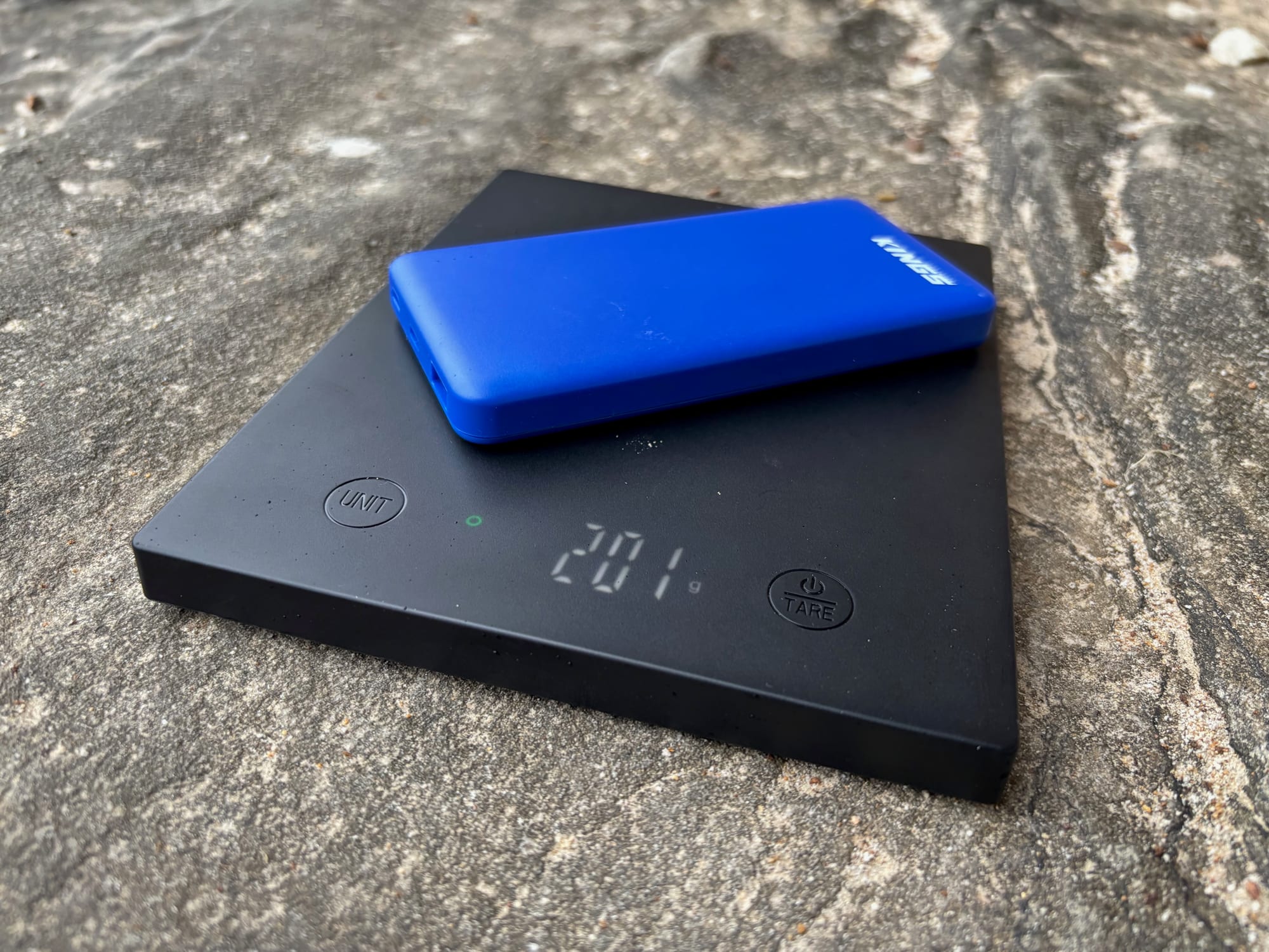 The blue Kings 10,000mAh power bank on a scale showing 201 g