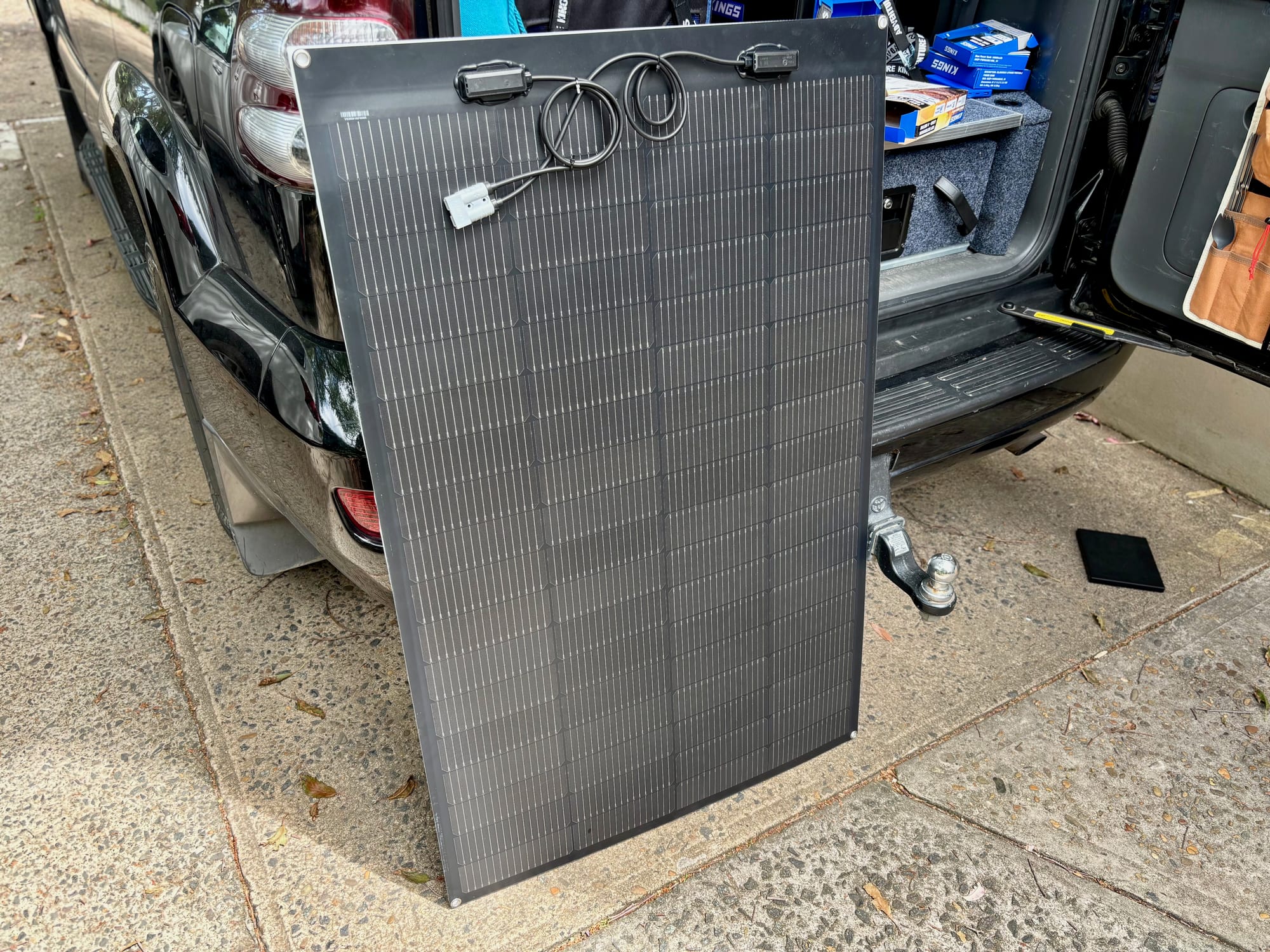 The Kings 160W semi-flexible solar panel standing at the back of the car