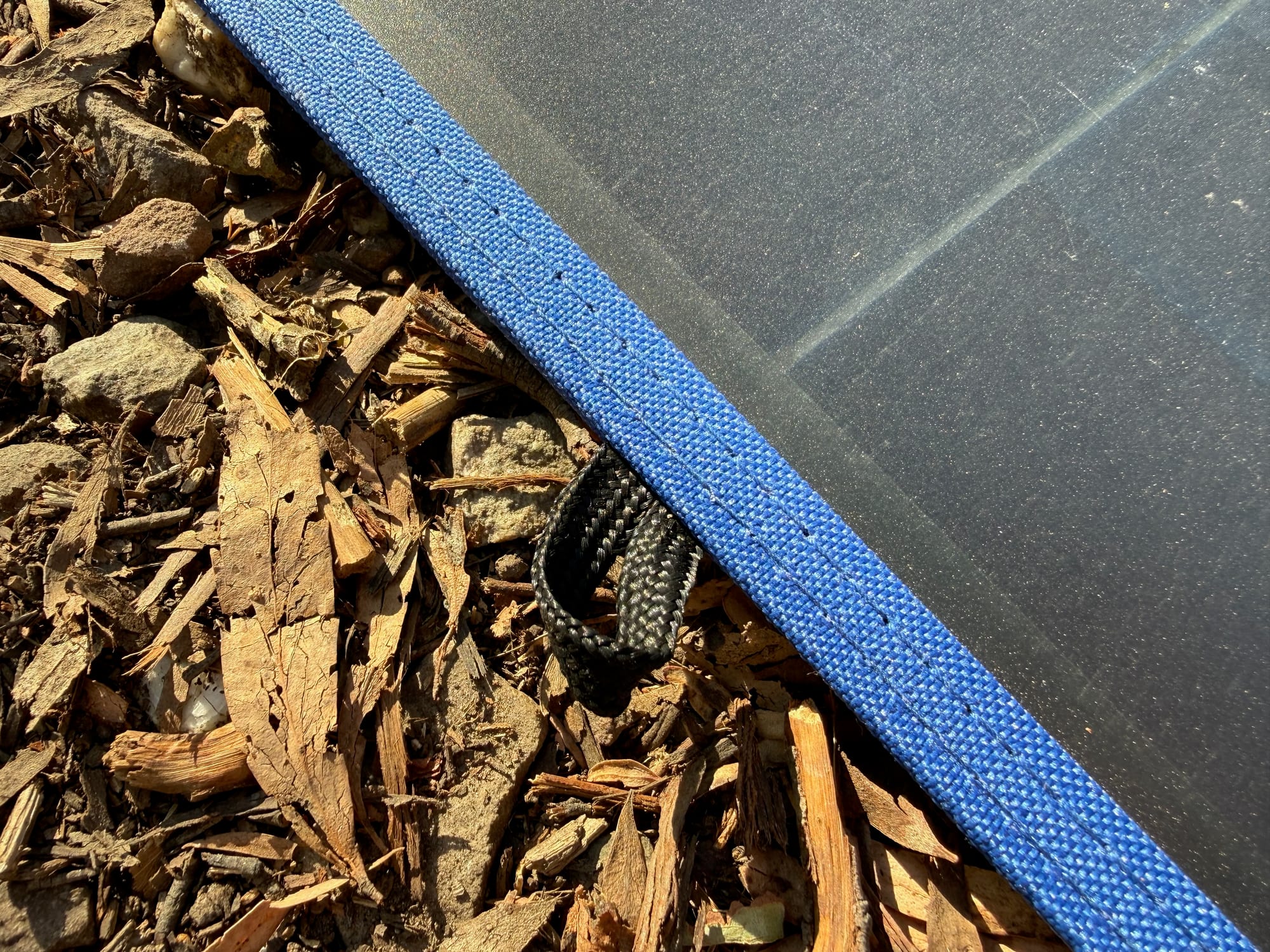 The stitched blue edging of the Kings 240W solar blanket with one of the loops for hanging it up