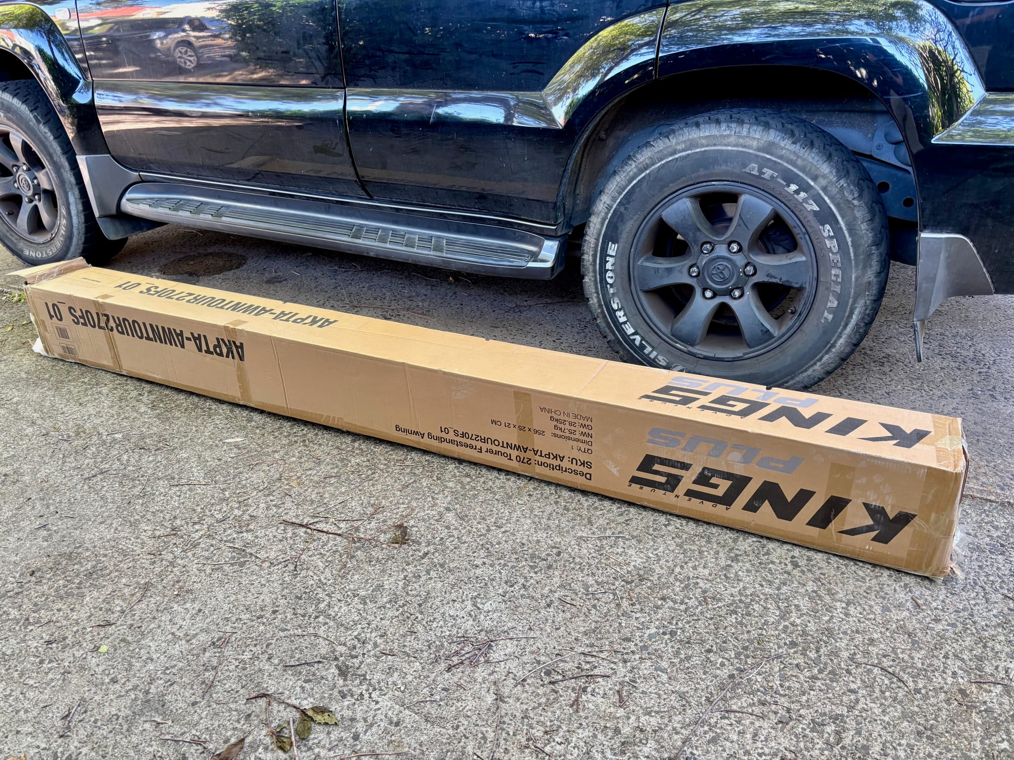 The long Kings box of the 270 Tourer awning on the ground next to our Prado