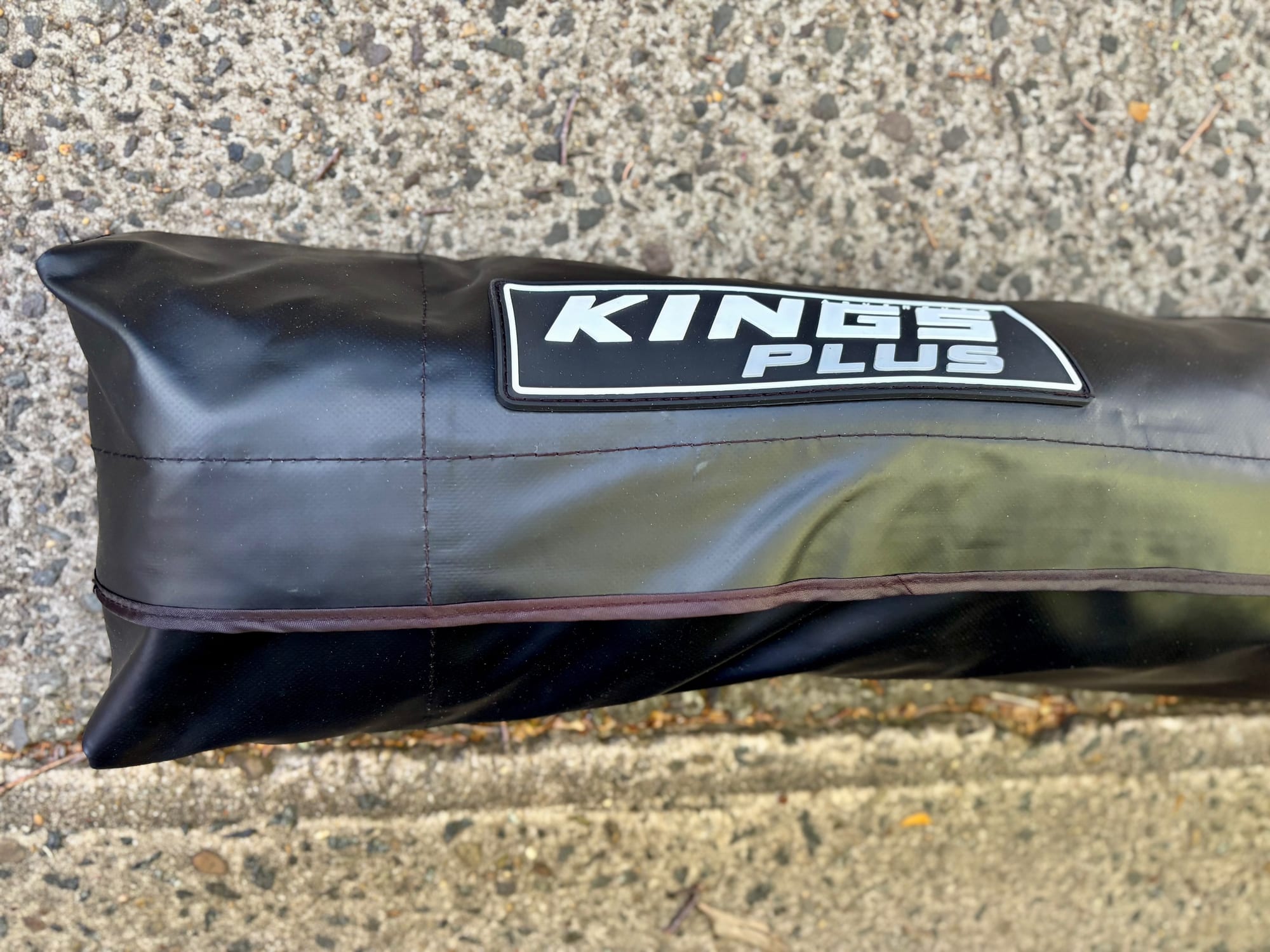 The black Kings Plus awning cover with its logo badge
