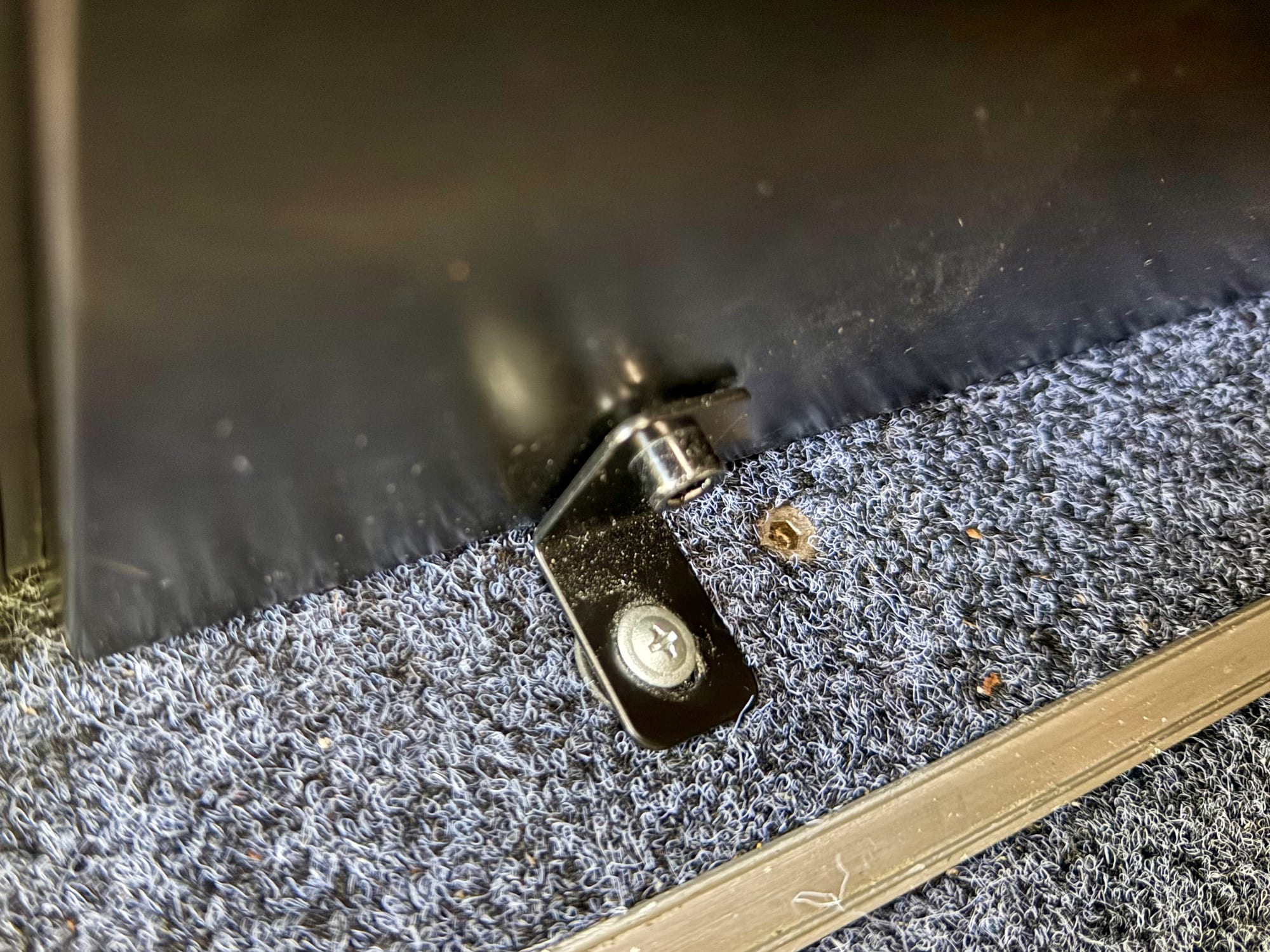 An L-bracket bolting the base of the Kings drawer fridge cabinet to the drawer system