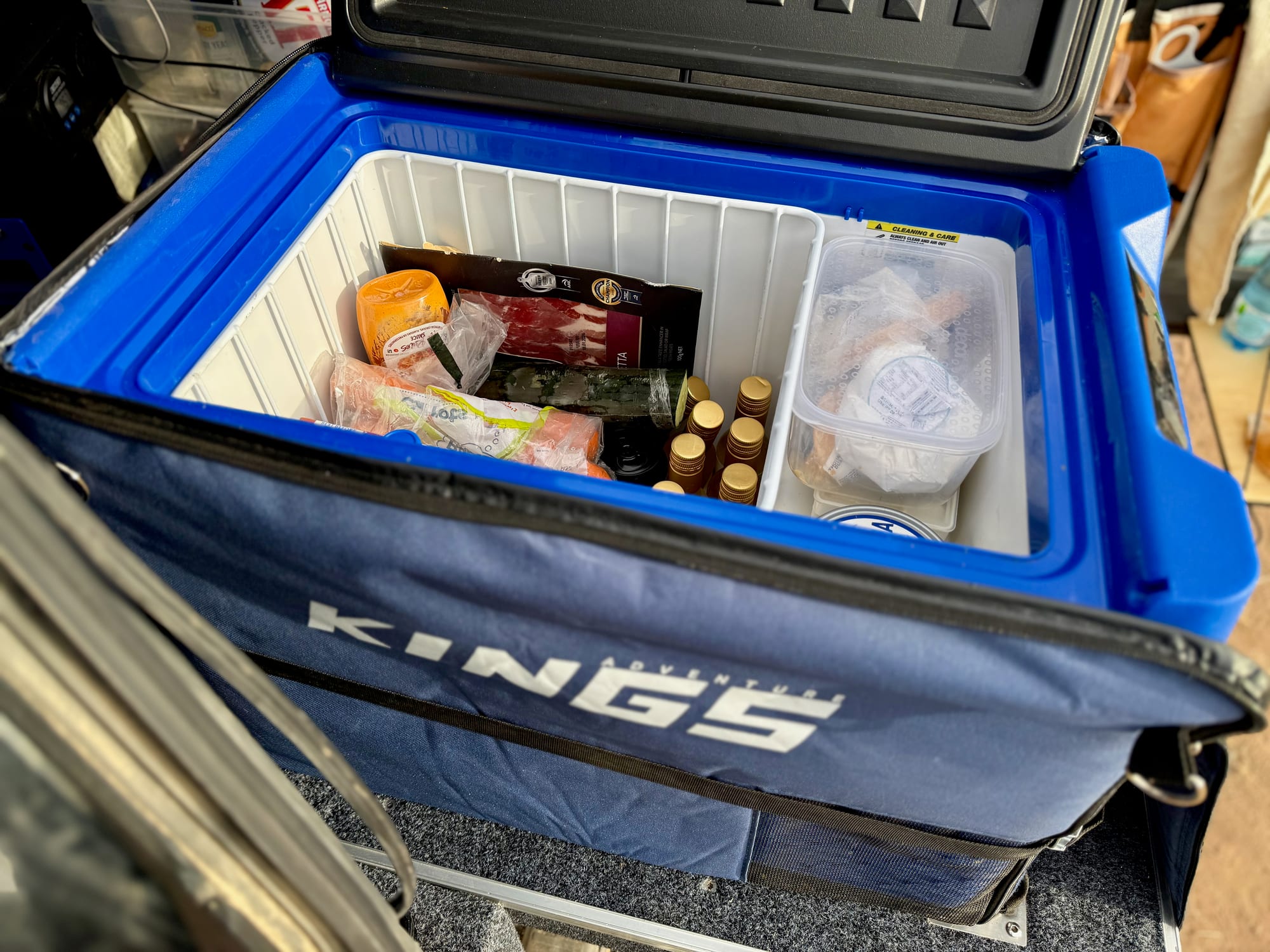 The Kings 40L fridge in its blue and black Kings cover, packed with food and drinks