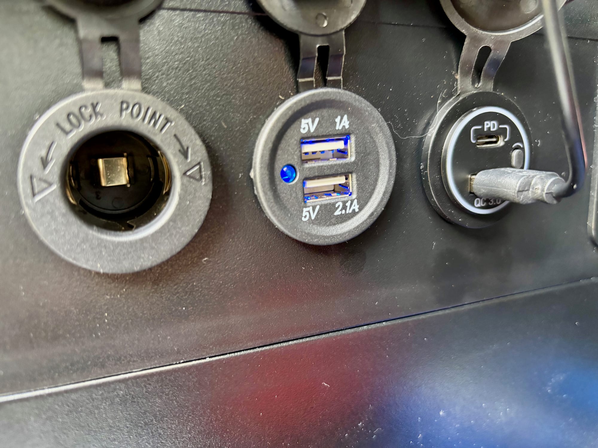 The 12V cigarette socket and USB ports on the side of the BatBlock, with their caps open