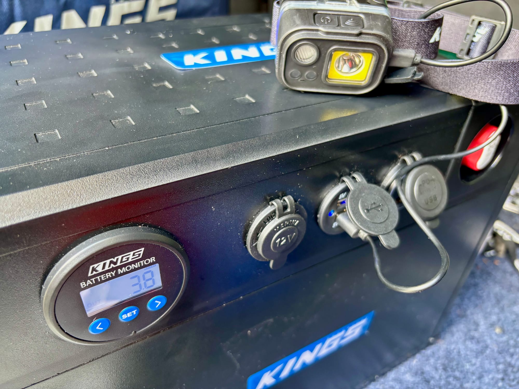 The side of the BatBlock 25 with the battery monitor, the 12V socket and two USB sockets, a head torch on top