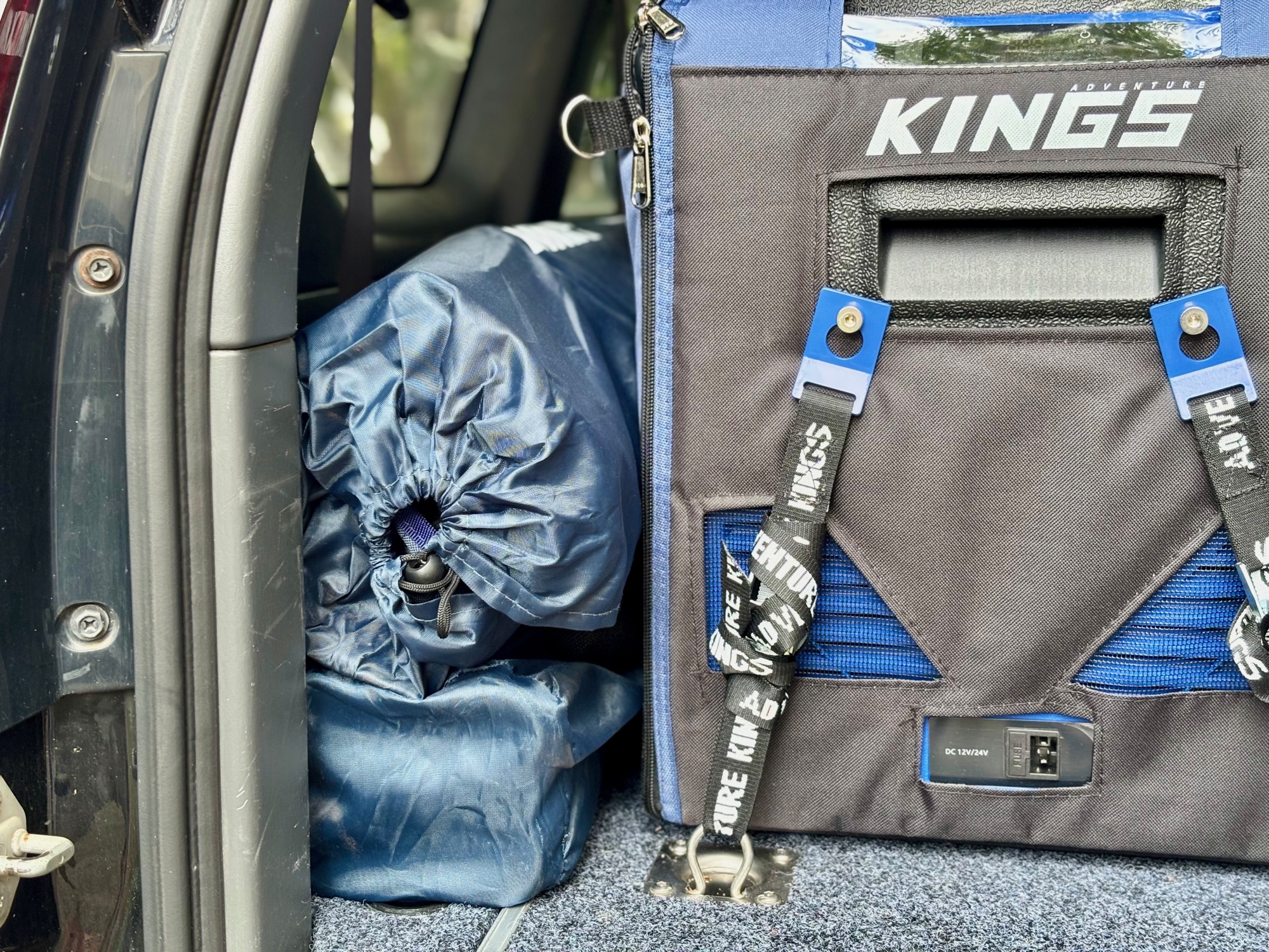 The Kings Deluxe Armchair in its bag in the car boot next to a Kings fridge