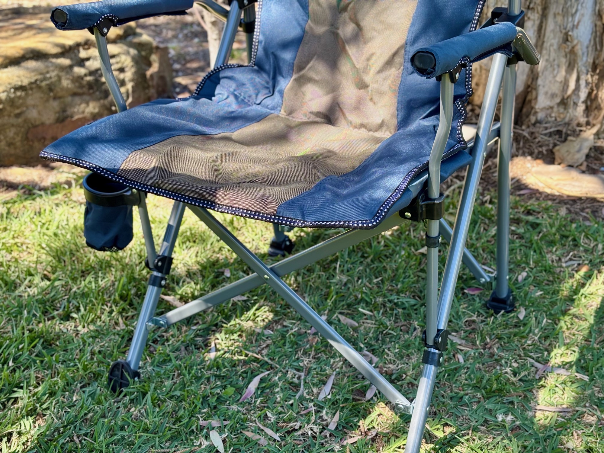 The padded seat and armrests of the Kings Deluxe Armchair, with the drink holder and steel frame