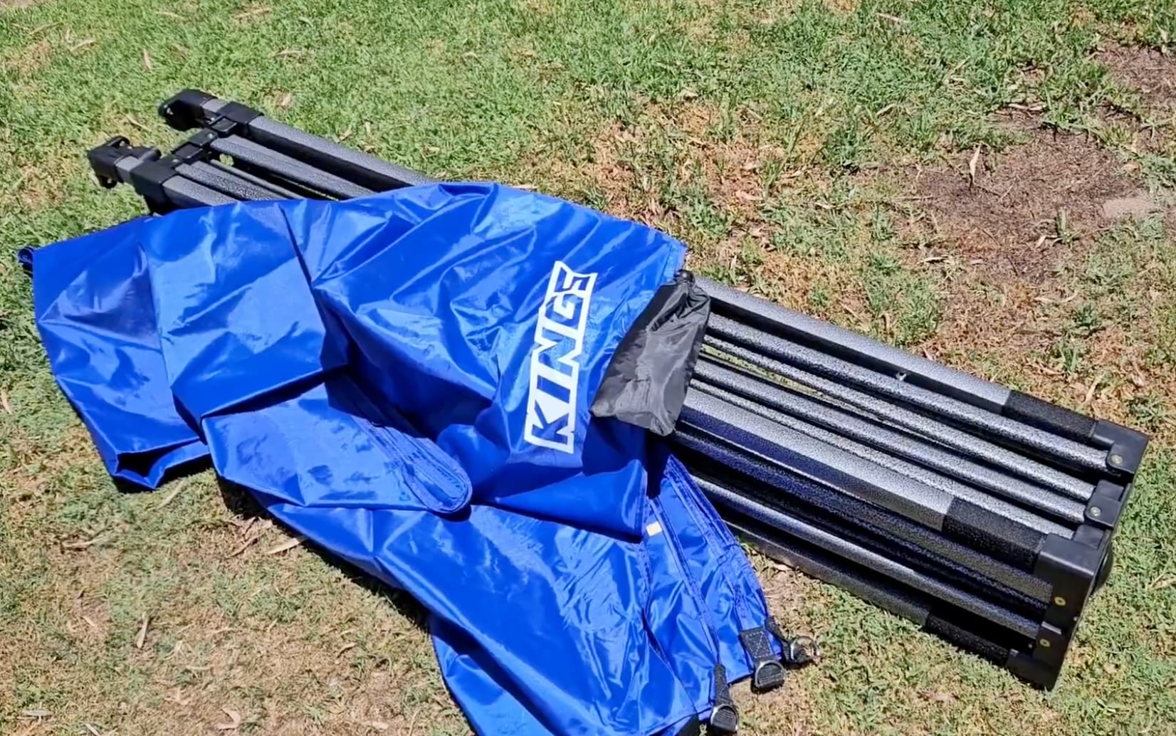 The Kings gazebo folded down, with the blue canopy lying over the closed steel frame