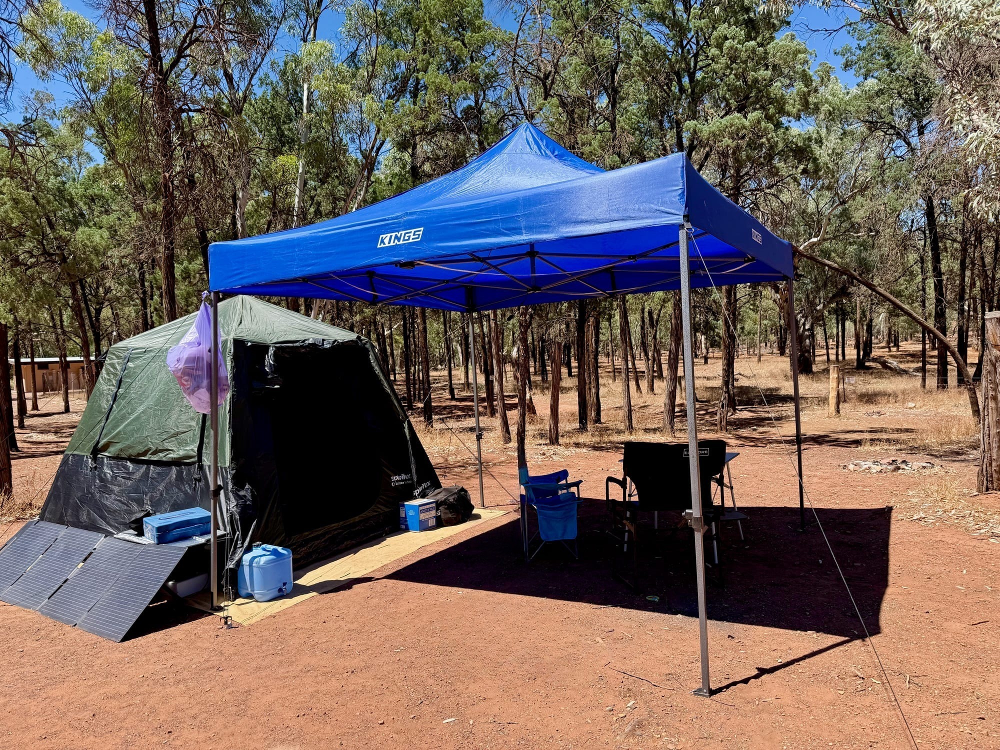 The Kings gazebo set up over the camp table and chairs next to the tent