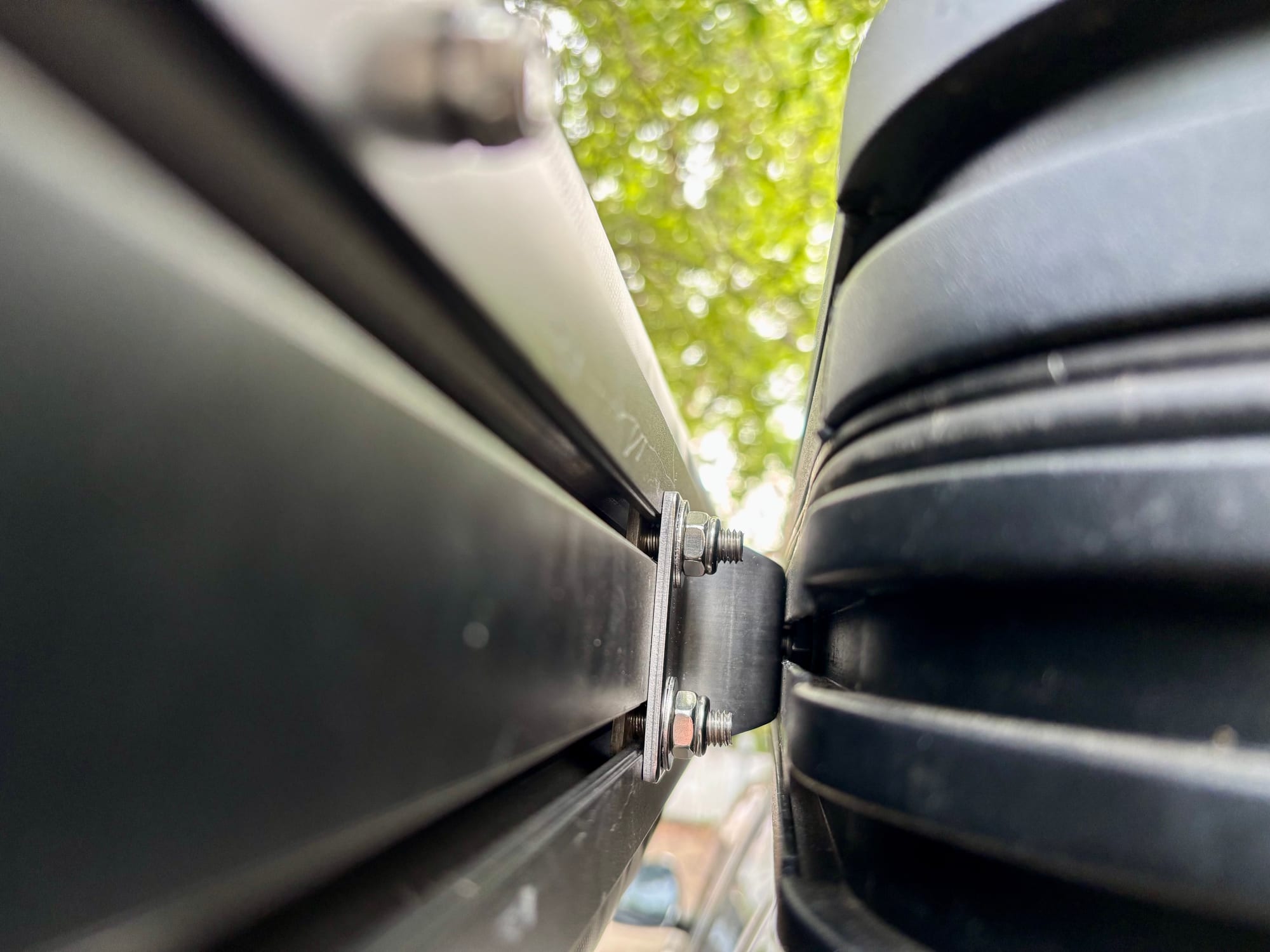 Close-up of a stainless bracket bolted between the awning and the side of the rooftop tent