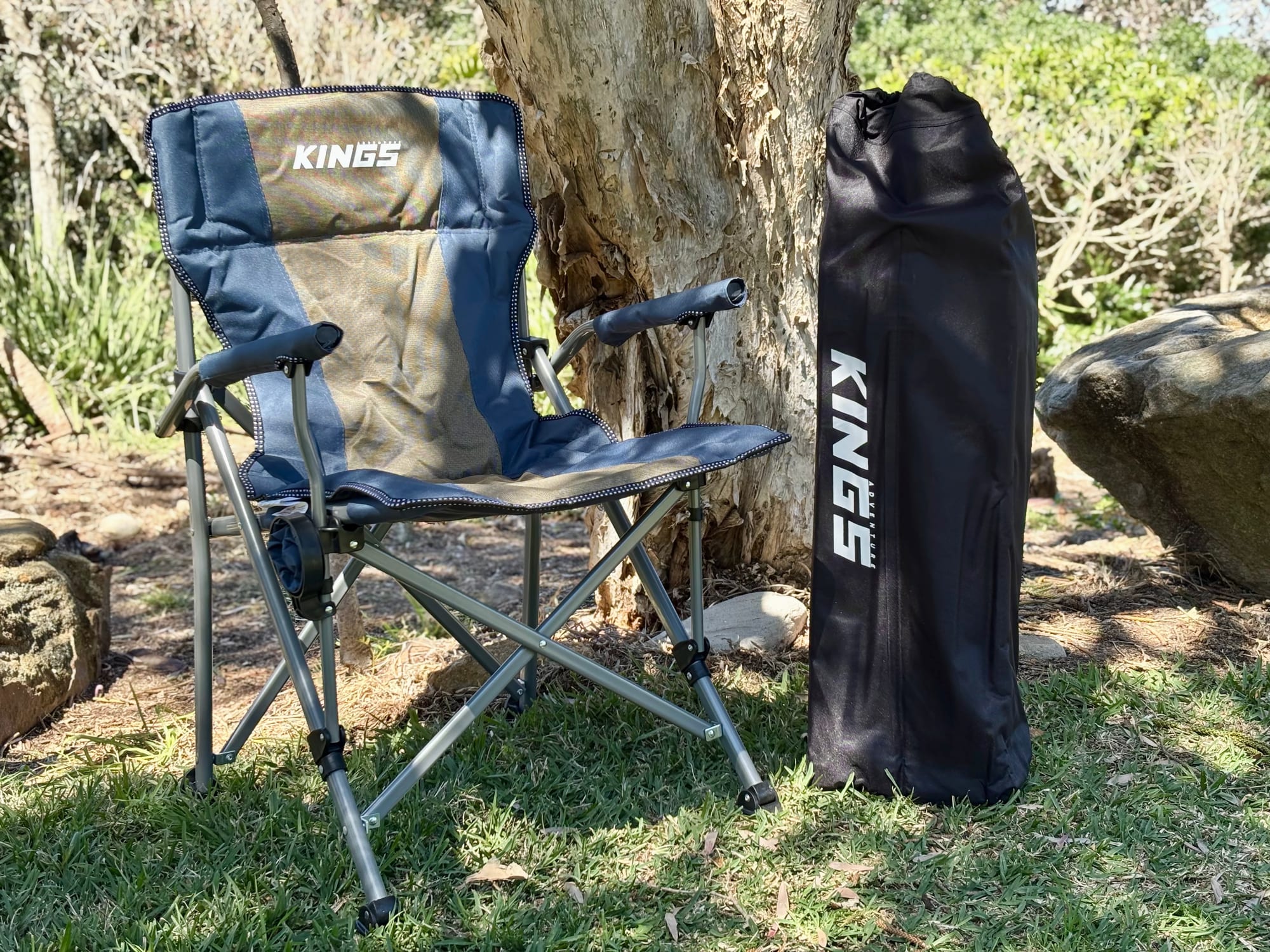 The Kings Large table packed in its carry bag, standing next to a Kings Deluxe Armchair