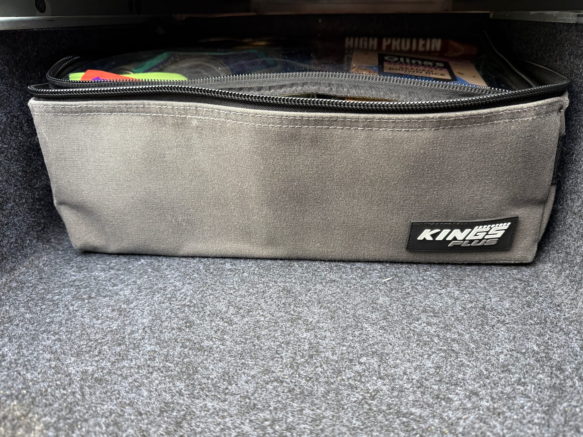 A grey Kings Plus clear top bag, packed and zipped, fitting snugly in the drawer of our 4WD