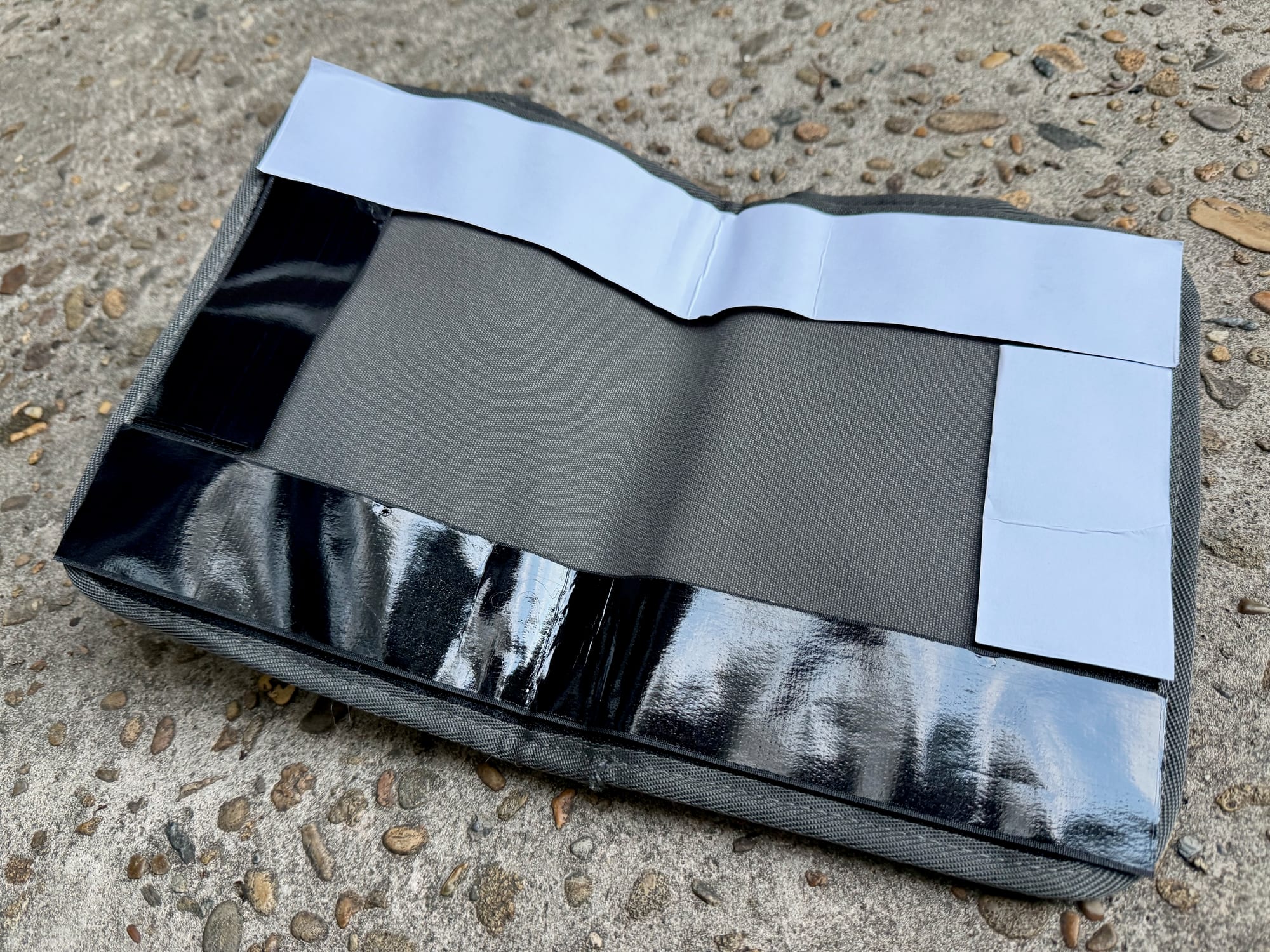 The adhesive strips on the back of the pocket organiser with the backing peeled off
