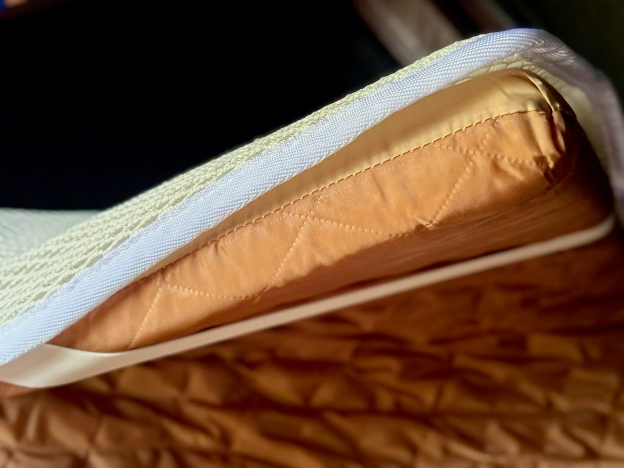 An elastic strap of the Kings anti-condensation mat wrapped around a corner of the rooftop tent mattress
