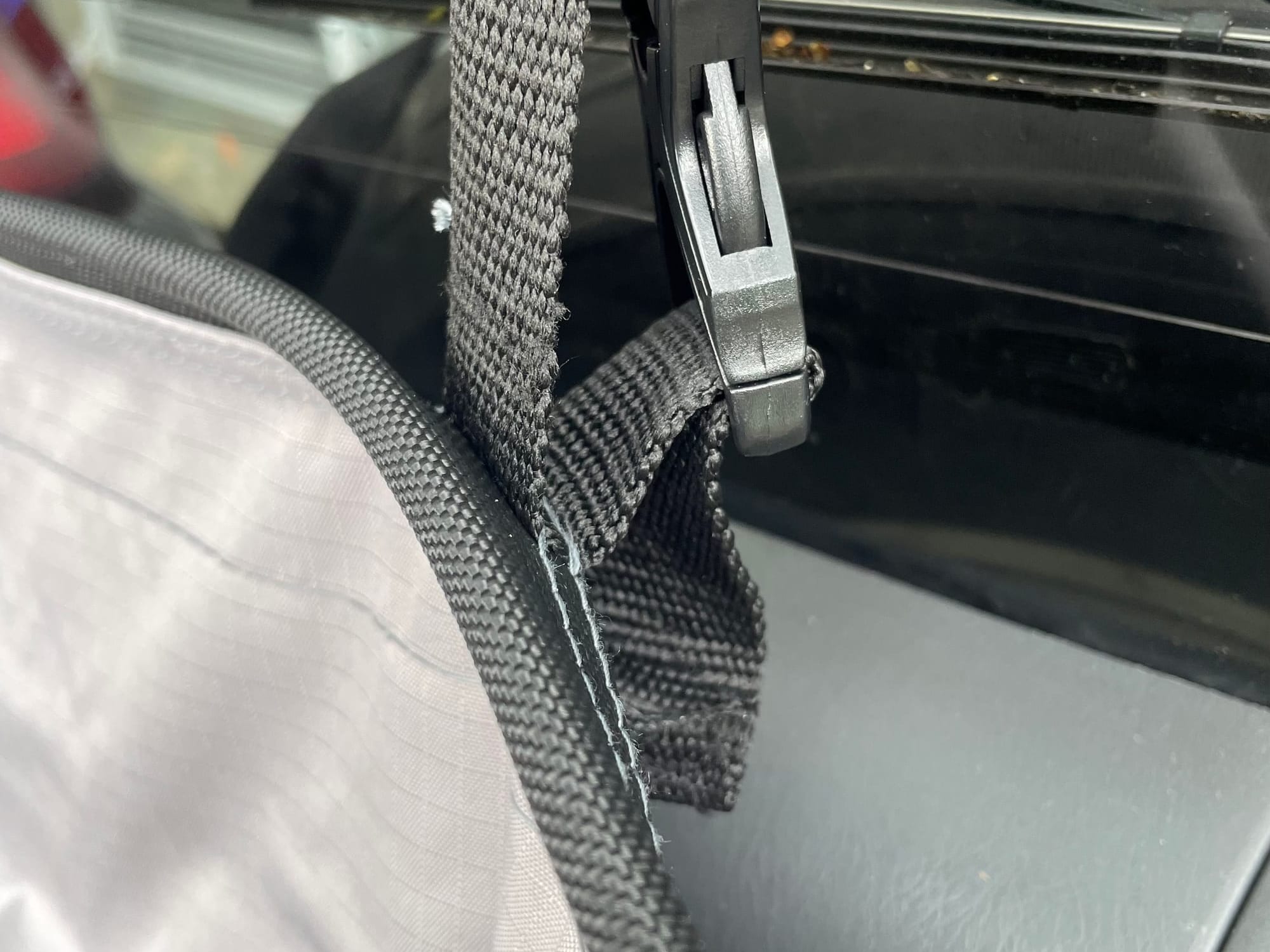 A black quick-release clip on the webbing strap of the Kings storage bag
