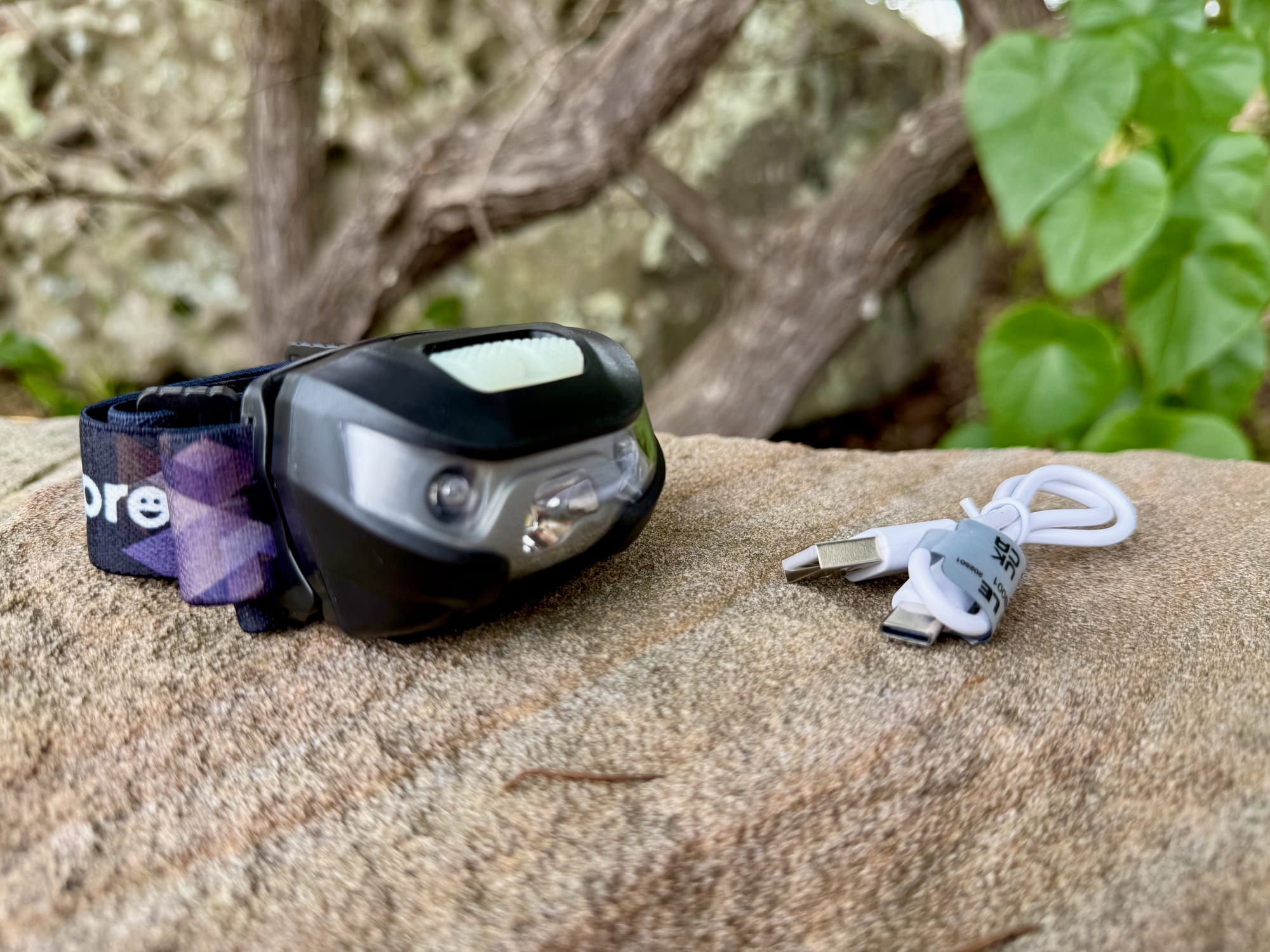 The Lepro 3200008 headlamp with its white USB charging cable