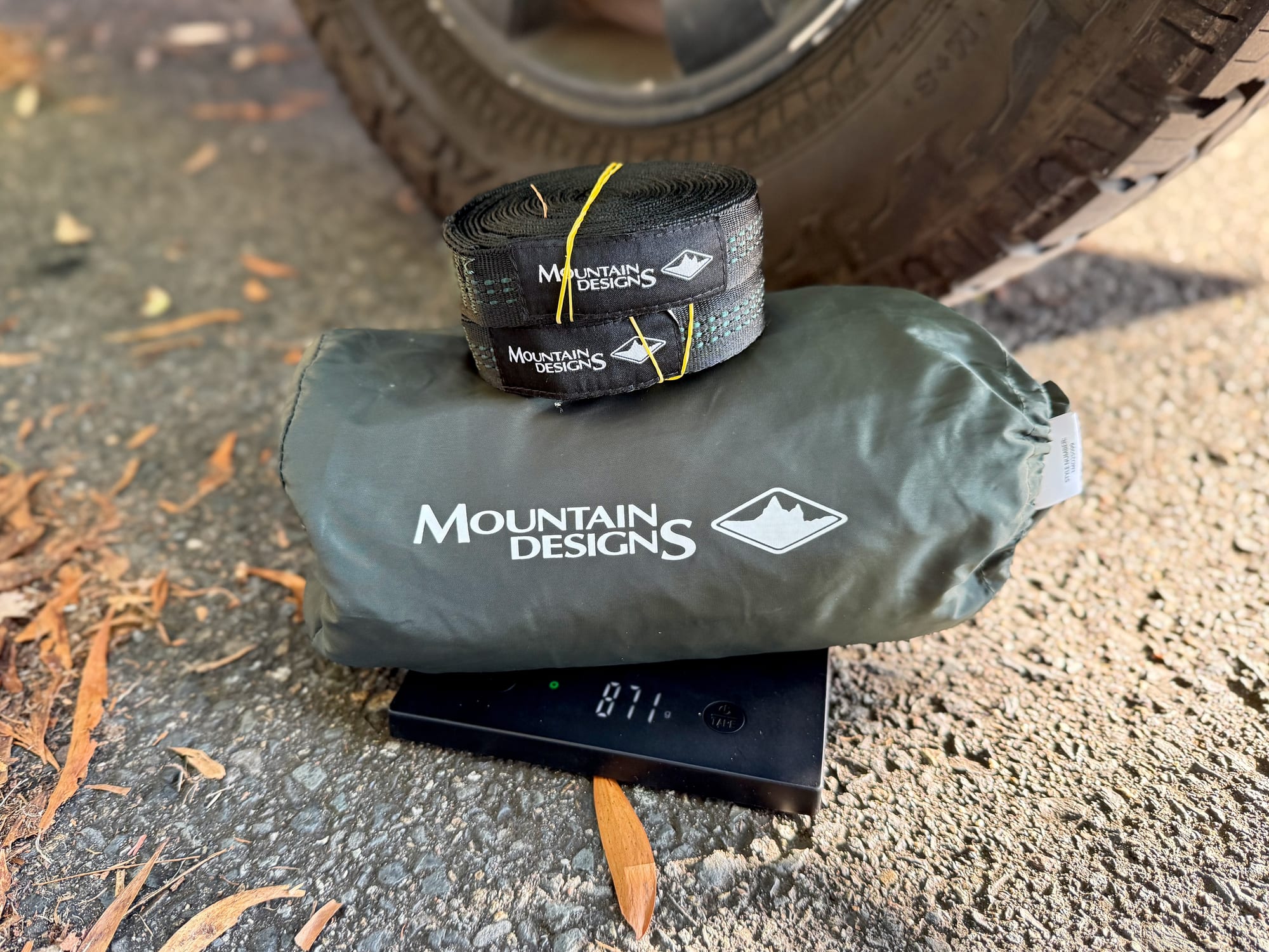The packed Mountain Designs hammock and its straps on a kitchen scale showing 871 g