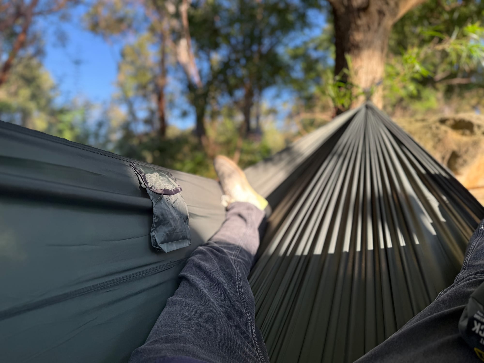 Lying in the dark green Mountain Designs double hammock, looking past my feet to the tree it hangs from