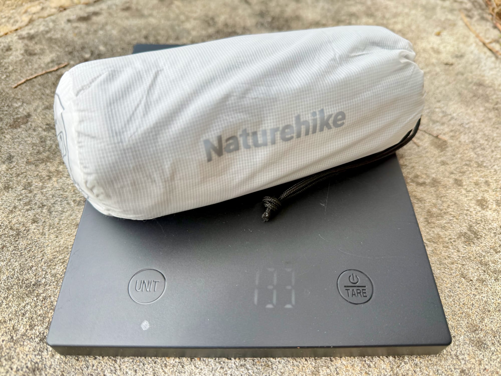 The Naturehike sleeping bag liner in its stuff sack on the scale, at about 133 g