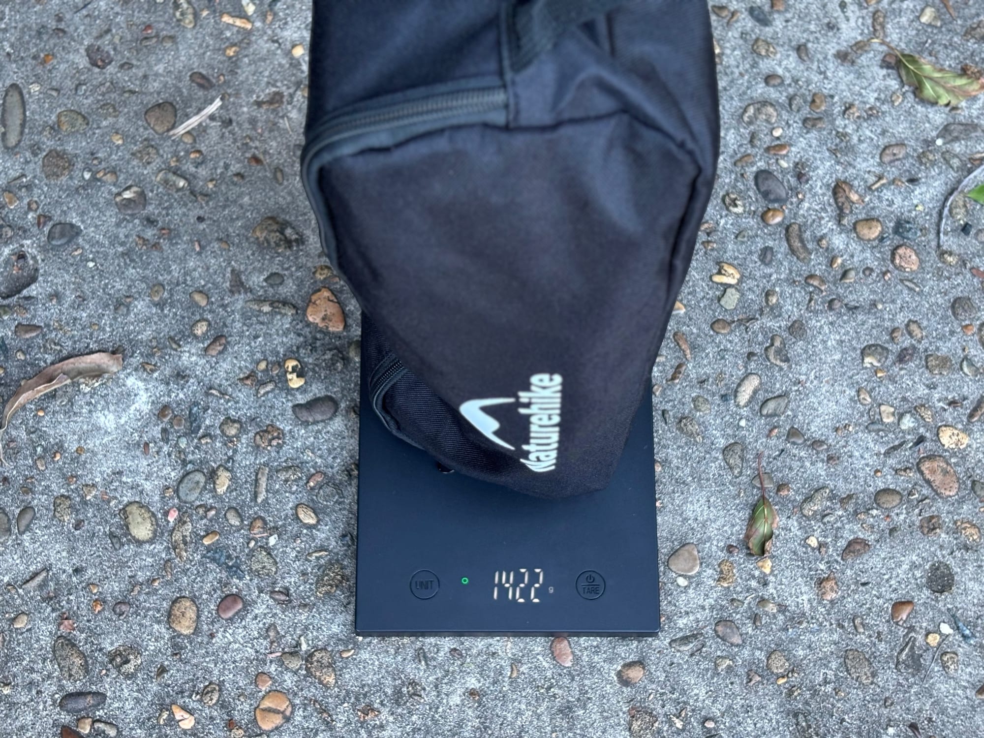 The Naturehike YL01 in its carry bag on a kitchen scale showing 1,422 g