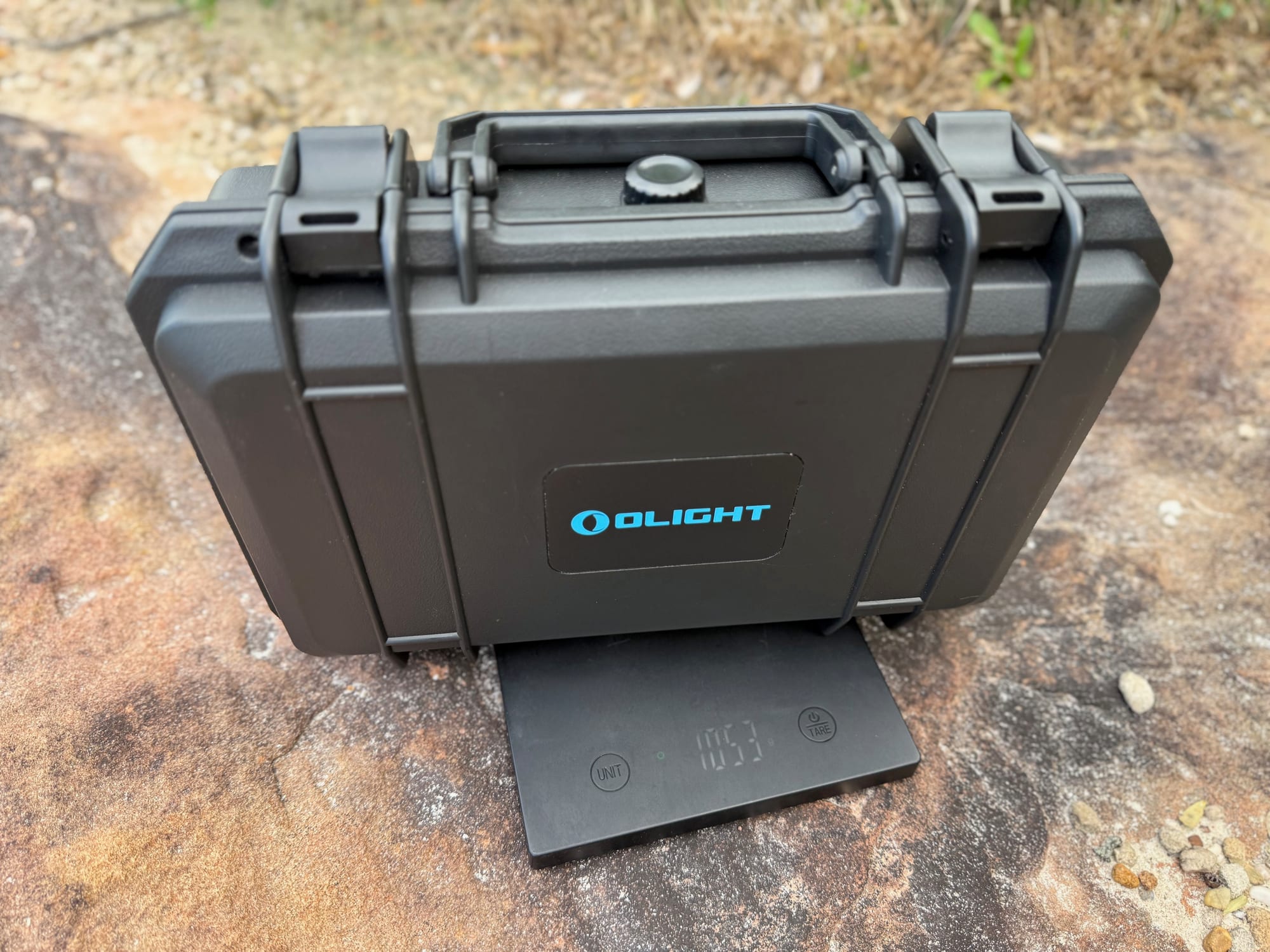 The closed Olight hard case of the Javelot Pro 2 hunting kit on a rock