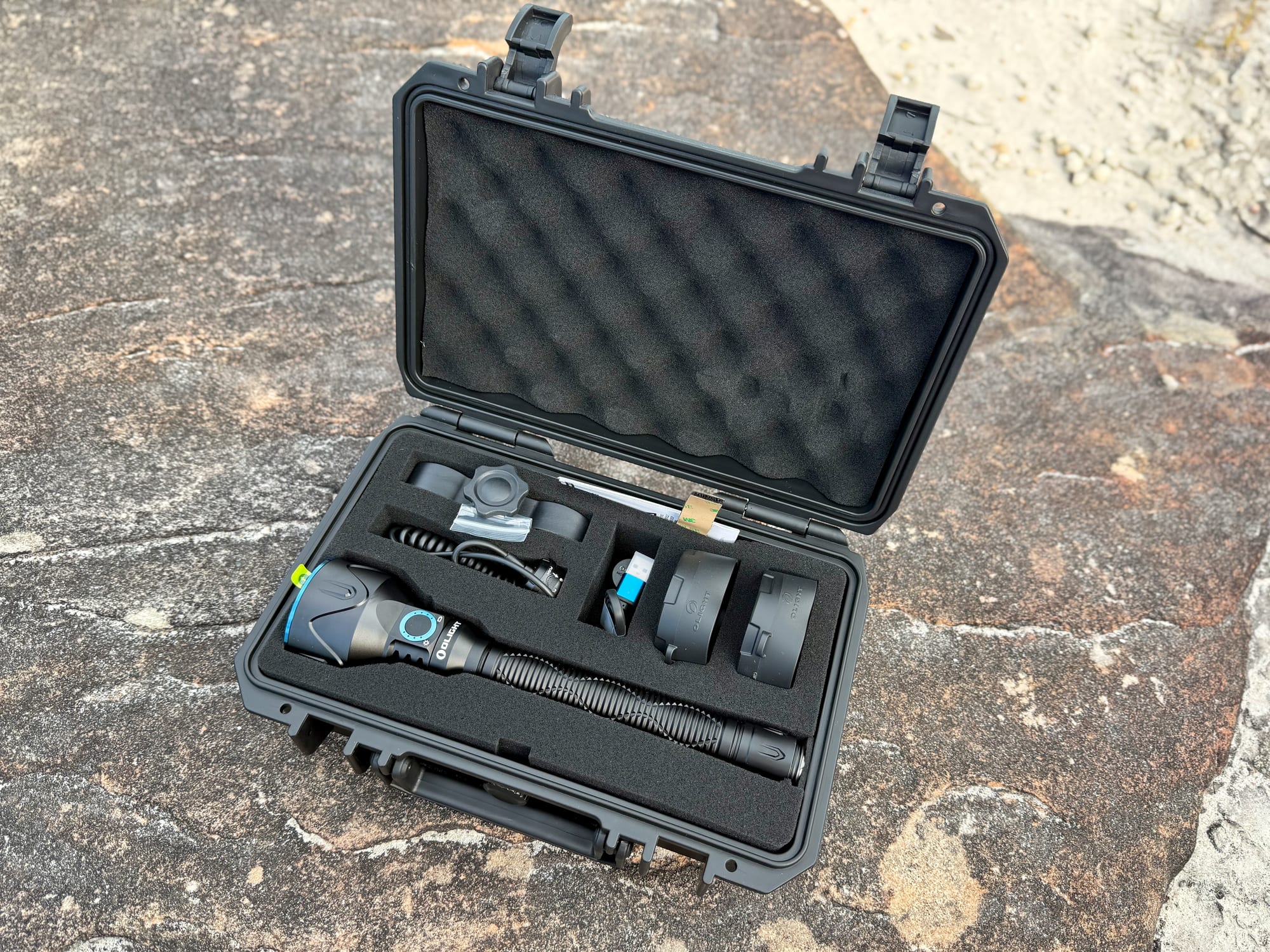 The Javelot Pro 2 hunting kit in its open hard case: torch, remote switch, mount, filters and cable in foam cut-outs